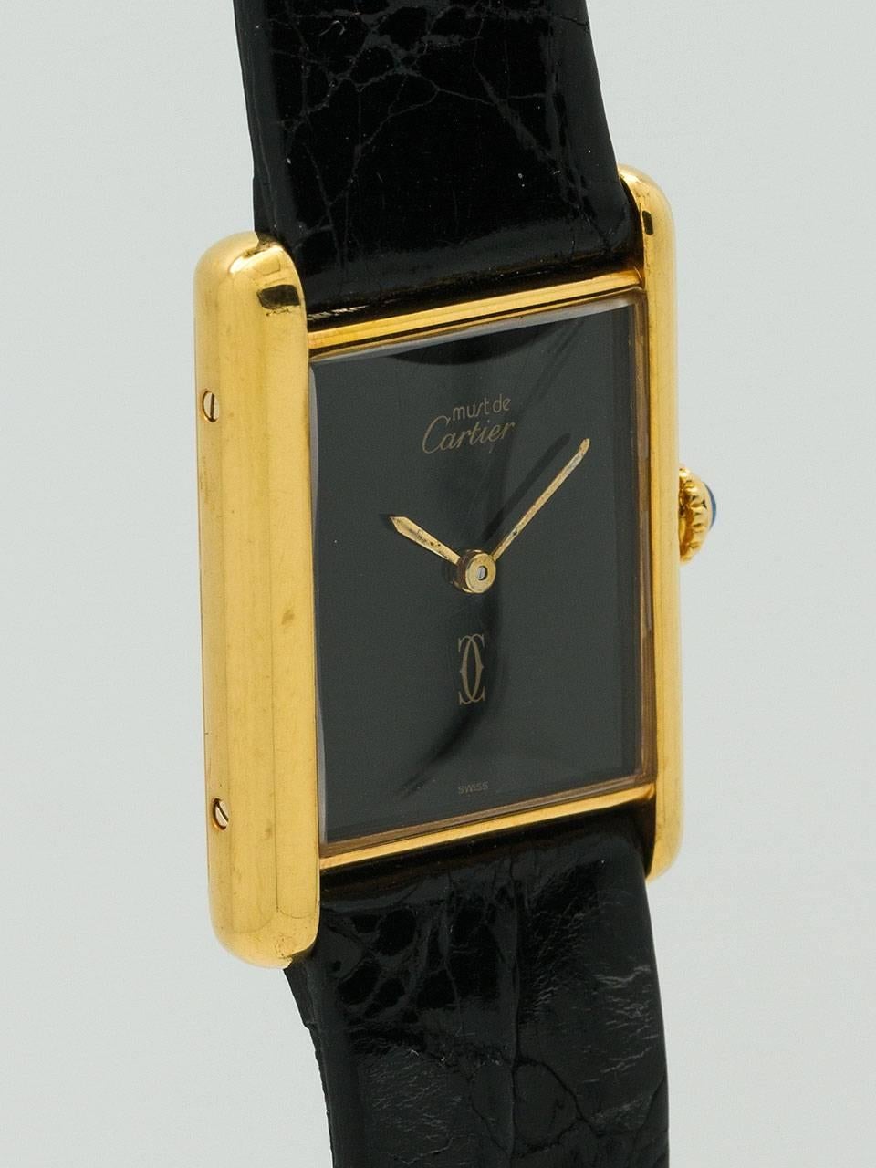 Cartier Man's Vermeil Tank Louis Must de Cartier, circa 1970s. Vermeil, 20 microns gold over silver, 23.5 X 31mm case secured by four screws. Classic black dial with Cartier double C logo and signed Must de Cartier, with gilt hands and blue sapphire