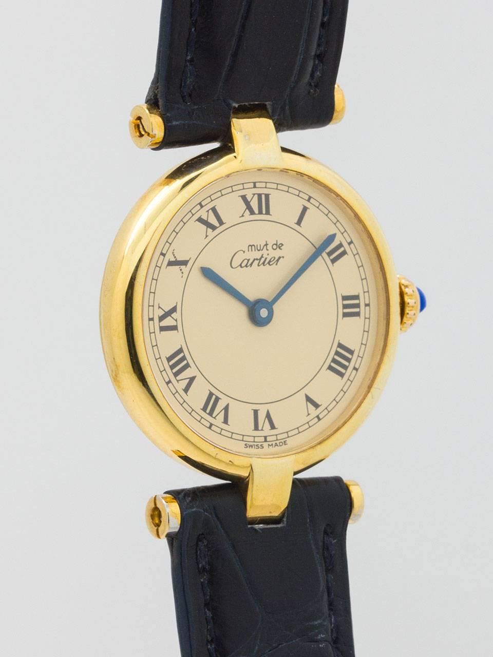 Cartier Lady’s Vermeil Vendome Tank Must de Cartier circa 1980s. 24.5 x 30mm round case with “T bar” lugs and acrylic crystal. Classic cream dial with black roman numerals, blue steeled hand, and blue cabochon sapphire crown. Battery powered quartz