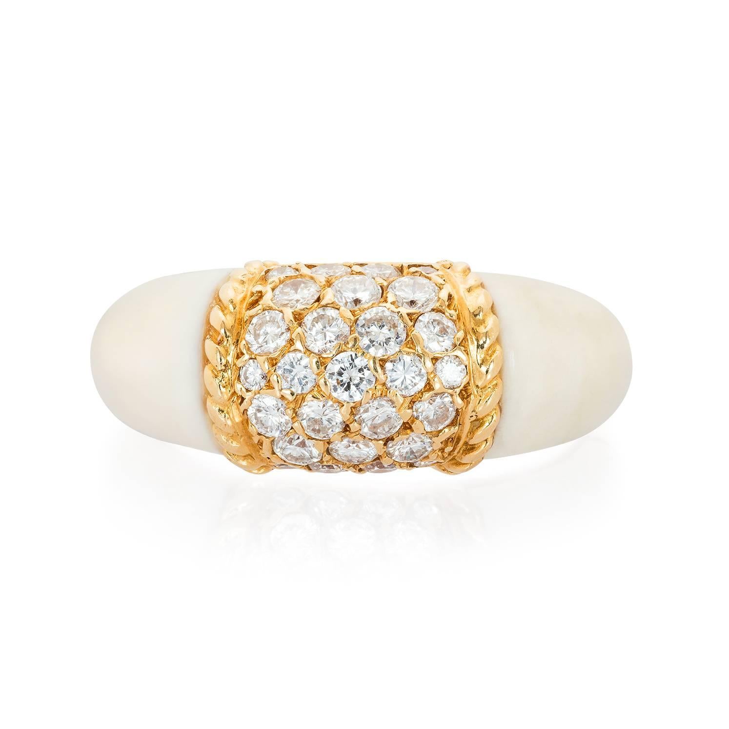 A rare white coral 'Philippine' ring by Van Cleef & Arpels, the larger than usual ring set to the centre with 27 round diamonds framed by a gold ropetwist border and flanked by white coral shoulders. Set in 18KT yellow gold. Signed and numbered,