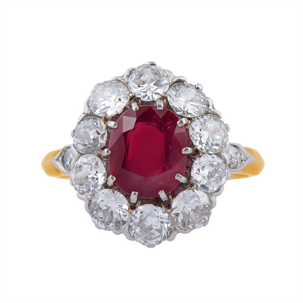 A Fine 18ct. Gold & Platinum Unheated Burmese Ruby & Diamond Cluster Ring, circa 1910, 10 claw-set at the centre with an oval mixed-cut ruby, weighing approximately 2cts, of pinkish red colour within a surround of 10 cushion-shaped diamonds,