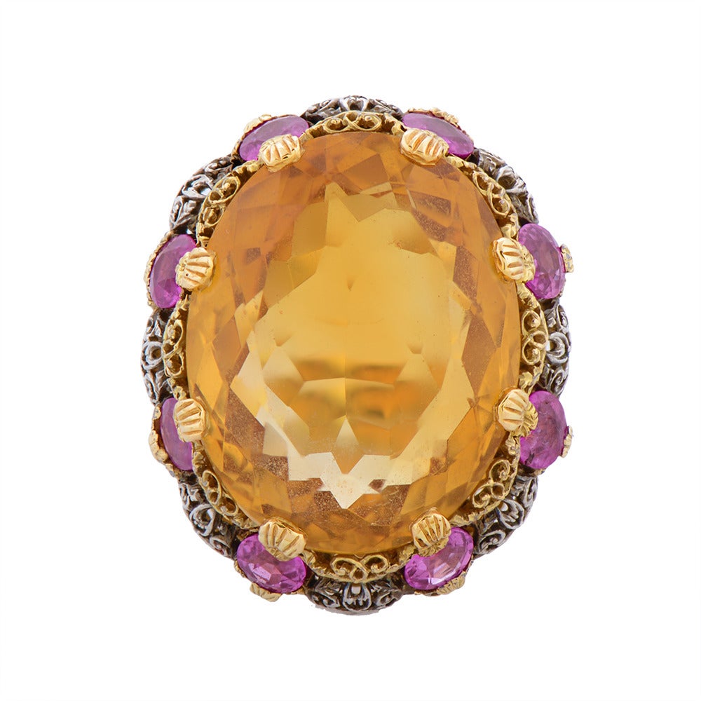 An Intricate Two-colour gold Citrine & Pink Sapphire Cocktail Ring, by Buccellati, Italian, circa 1950, eight claw-set at the centre with an oval mixed-cut stone estimated to weigh 25cts, the fine scroll carved openwork crown, gallery & shoulders