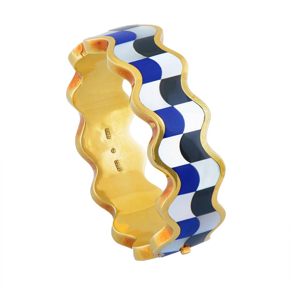 A Fine Gold, Onyx, Lapis Lazuli & Mother of Pearl Bangle by Angela Cummings for Tiffany & Co, the wavy edged form decorated with blue lapis, black onyx and mother of pearl panels, marked 18kt, stamped T & Co ©. Circa 1980.