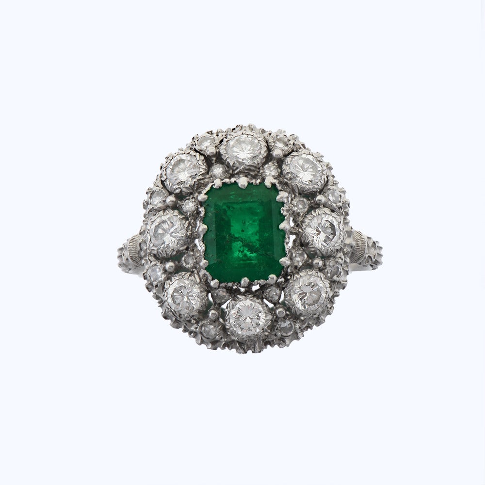 Circa 1970, an emerald and diamond dress ring by Buccellati, the emerald to the centre of a textured platinum mount, set with diamonds.

Ring Size - N (can be resized)