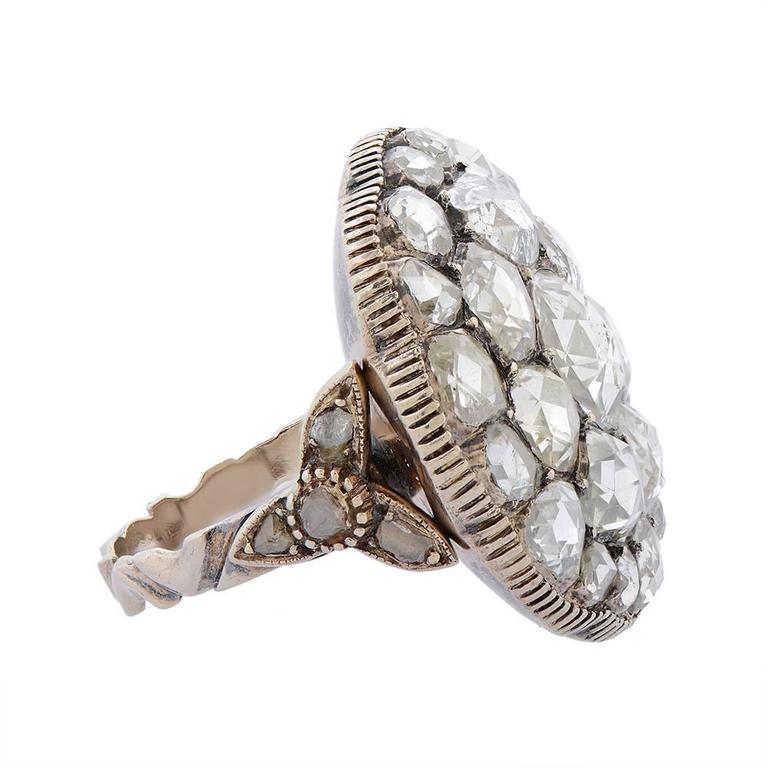 A rose cut diamond ring, French, designed as a large circular setting of rose-cut diamonds, enclosing one another in a rose-like formation, with a hand-engraved gallery, to decorative diamond-set shoulders of flower design, to an engraved shank,