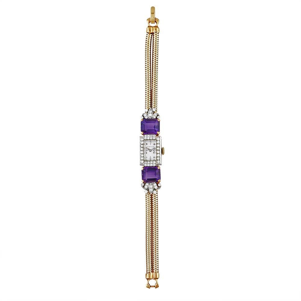 A platinum on gold, diamond and amethyst watch bracelet by Tiffany & Co, with 17 jewelled Swiss movement by Movado, mechanical, the dial signed TIFFANY & CO, in a rectangular 18K gold casing with diamond-set platinum bezel, to articulated shoulders