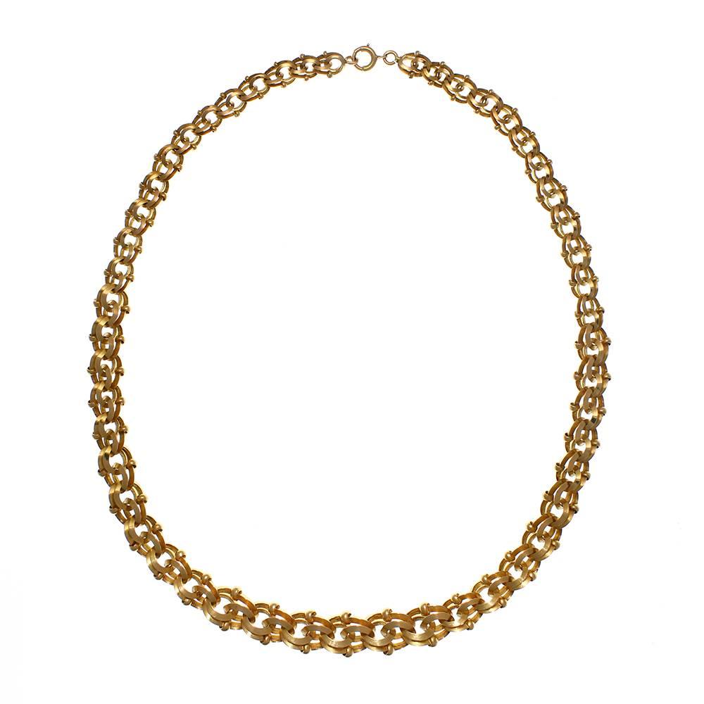 A rose gold double openwork necklace, French, composed of a chain of articulated openwork links, graduated and enclosed within an interconnected chain of larger links in loose figures of eight with pairs of small, fixed link accents. Measuring 45