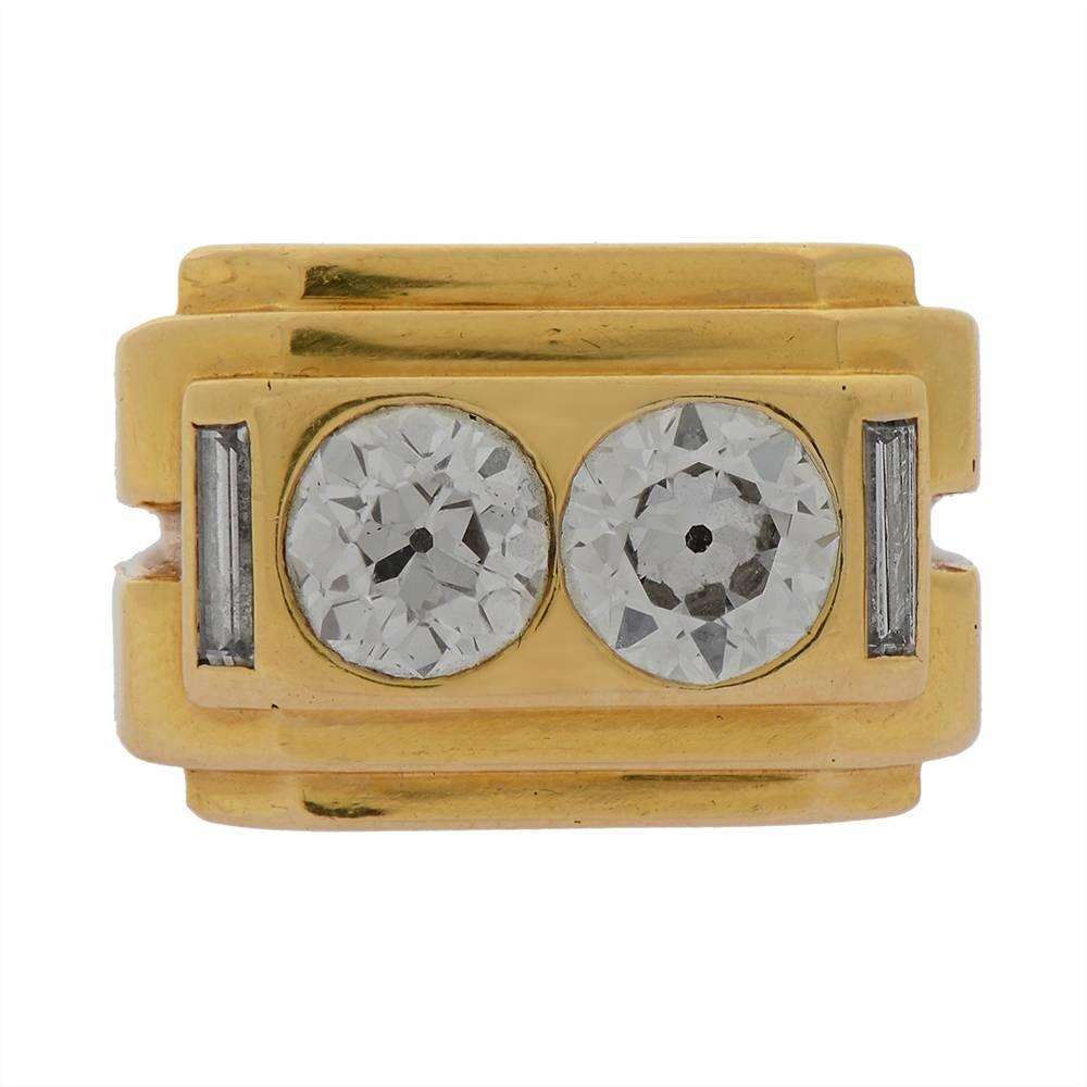 A two-stone gold and diamond ring by Van Cleef & Arpels, of geometric design, centring around a pair of round old European-cut diamonds, totalling approximately 2.5cts, bezel-set in a yellow gold, tiered surround and flanked on each shoulder by a