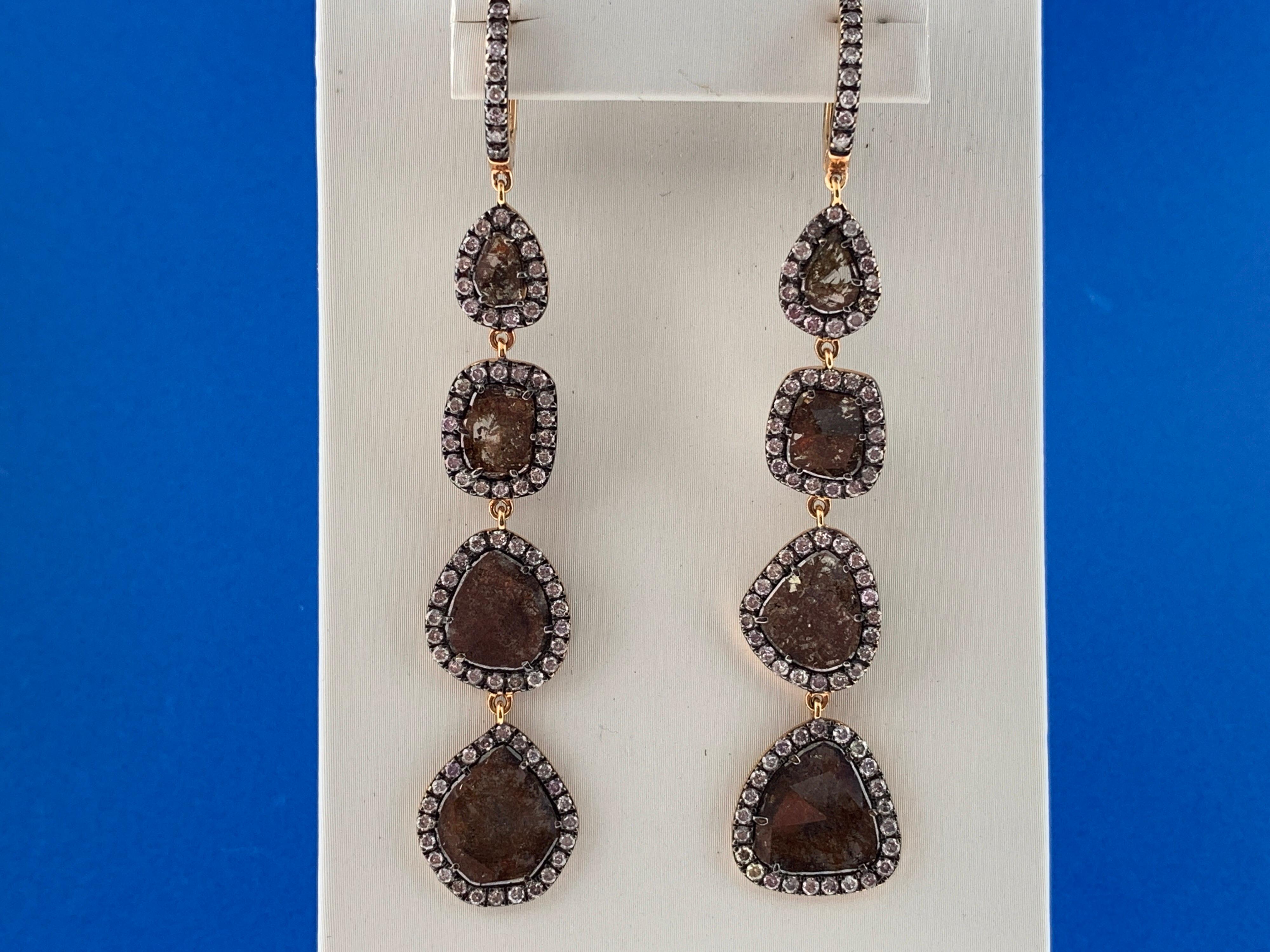 These stunning earrings feature 8 Rose Cut Slice Brown Diamonds, for a total of 5.97 Carats, each encircled in a single halo of round brilliant Diamonds, hanging from a Diamond hoop top. They are set in a 18k rose gold setting.
Total diamond weight
