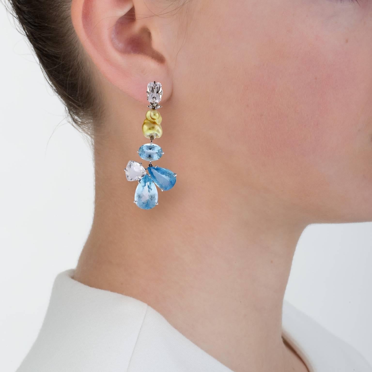 Irridescent blue aquamarine is offset with a south sea golden pearl in these large floaty earrings.

Known as the “feather dusters” they are linked to be very flexible and move with grace. Although large and spectacular the effect is delicate and