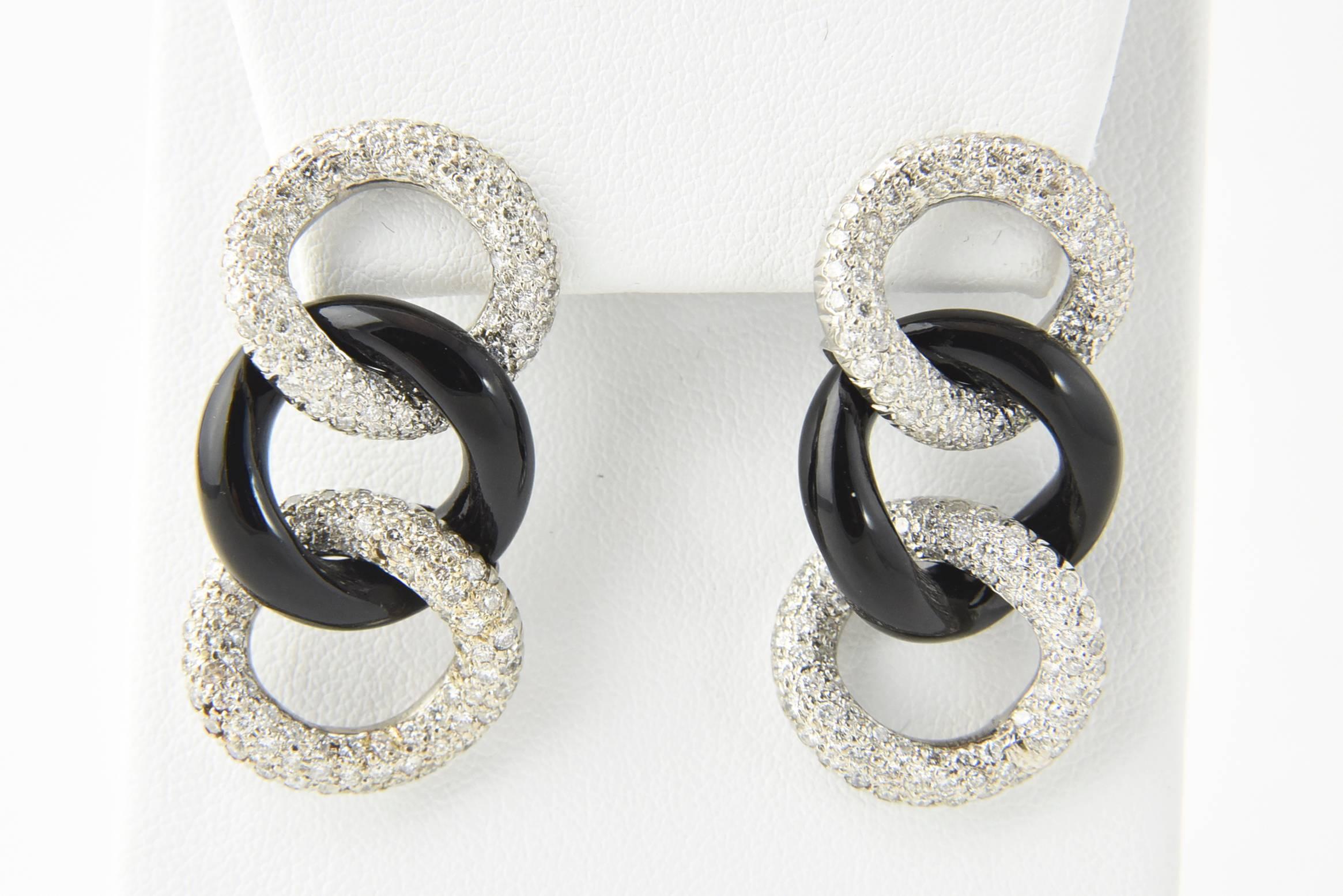 Elegant earrings featuring onyx and pave diamond links mounted in 18k white gold with 14k white gold backs.

They have posts.