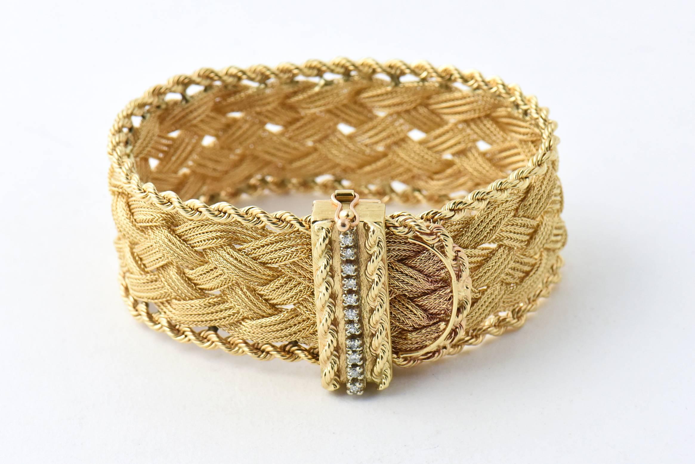 Wide 14k yellow gold buckle / garter bracelet with a braided woven center design and a rope edge.  The buckle continues the design with a row of prong set diamonds framed by 2 rows of rope.  

This bracelet is easily adjustable to most any size by