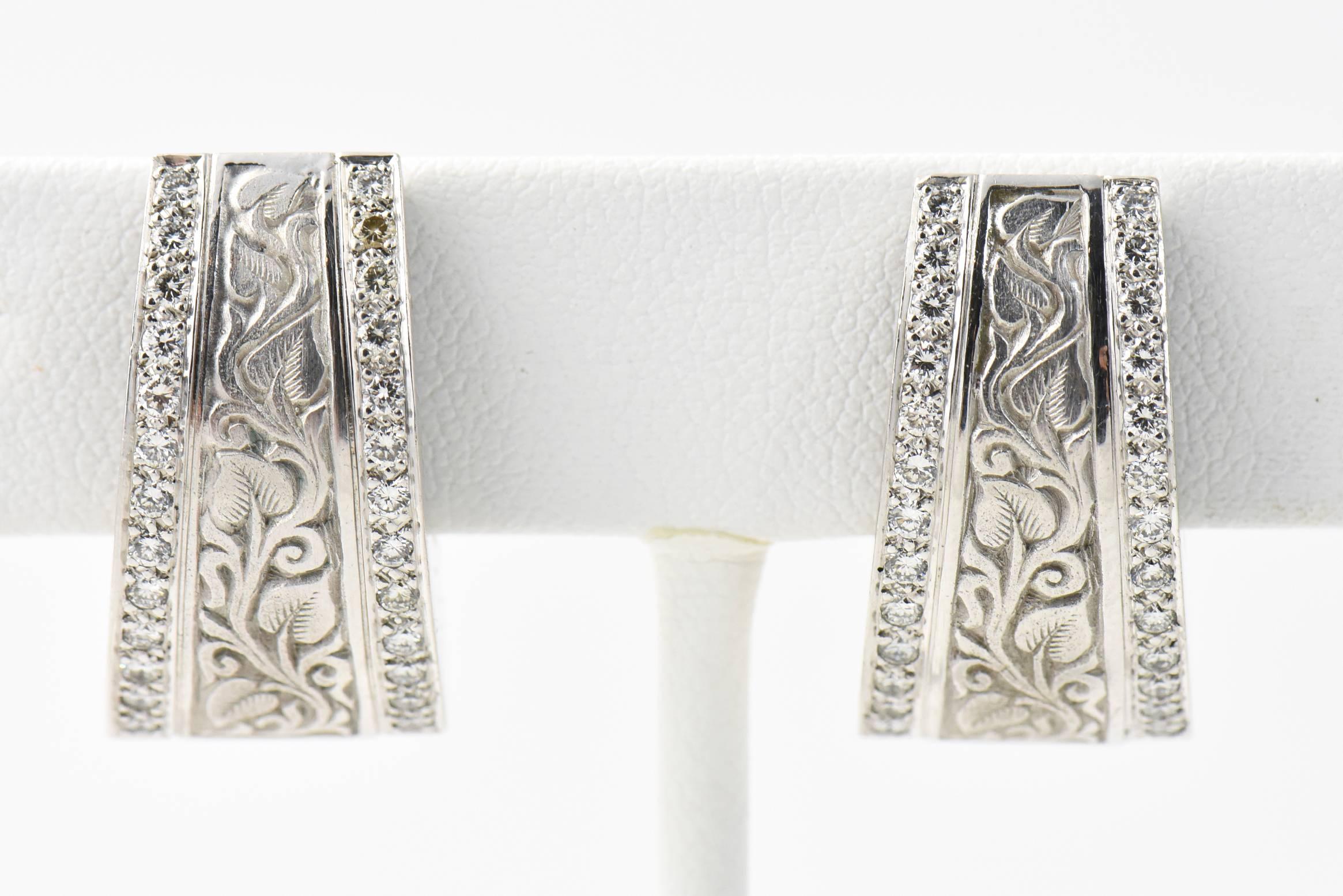 Beautifully made engraved 18k white gold hoop earrings with a leaf and vine design and pave diamond edges.

They have English hallmarks and an SW mark which I believe might be for the Jeweler Simon Wright.