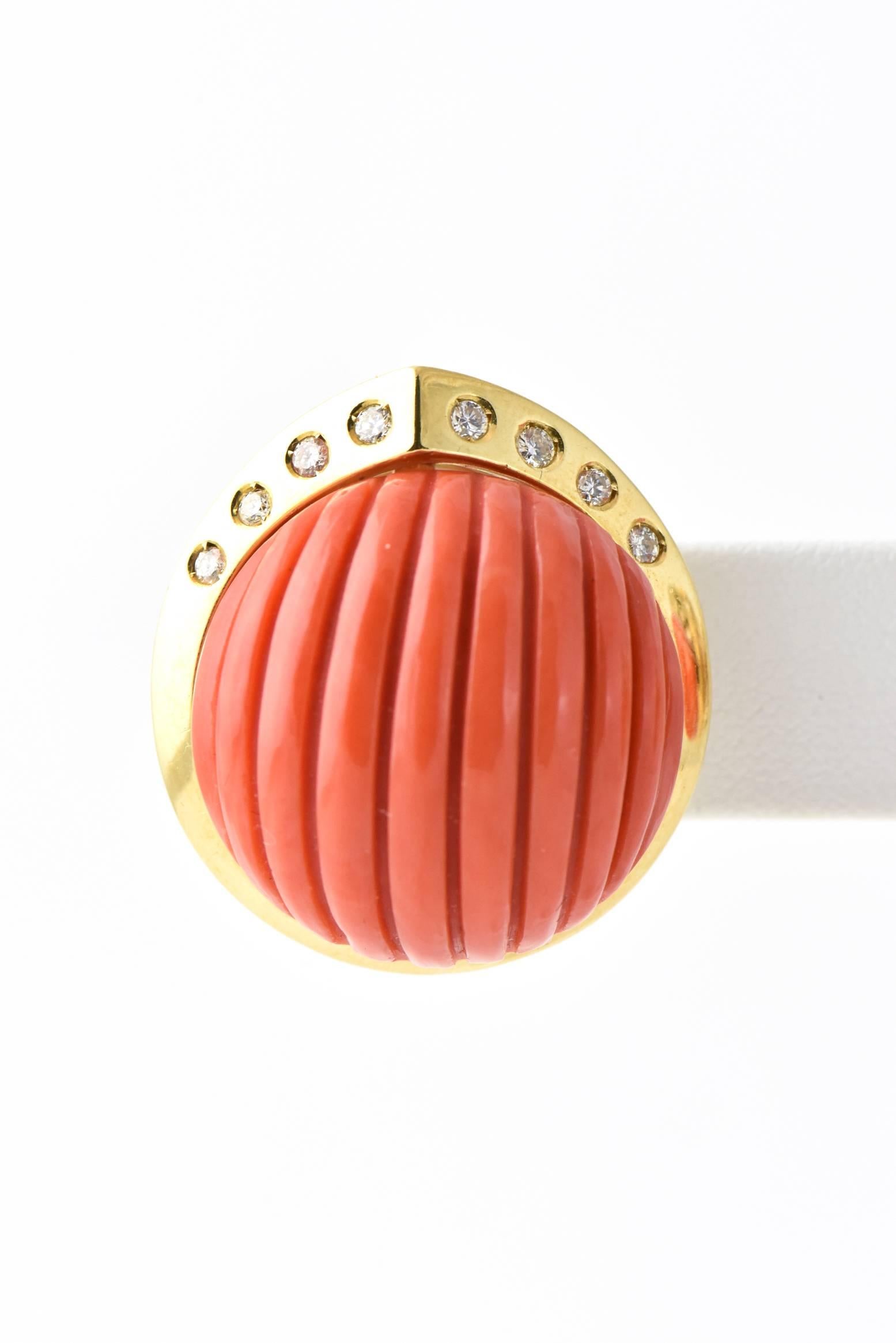 Large ribbed coral cabochon with diamond accents in an 18k yellow gold frame.  It sits on the ear and is hold in place with a post and clip.