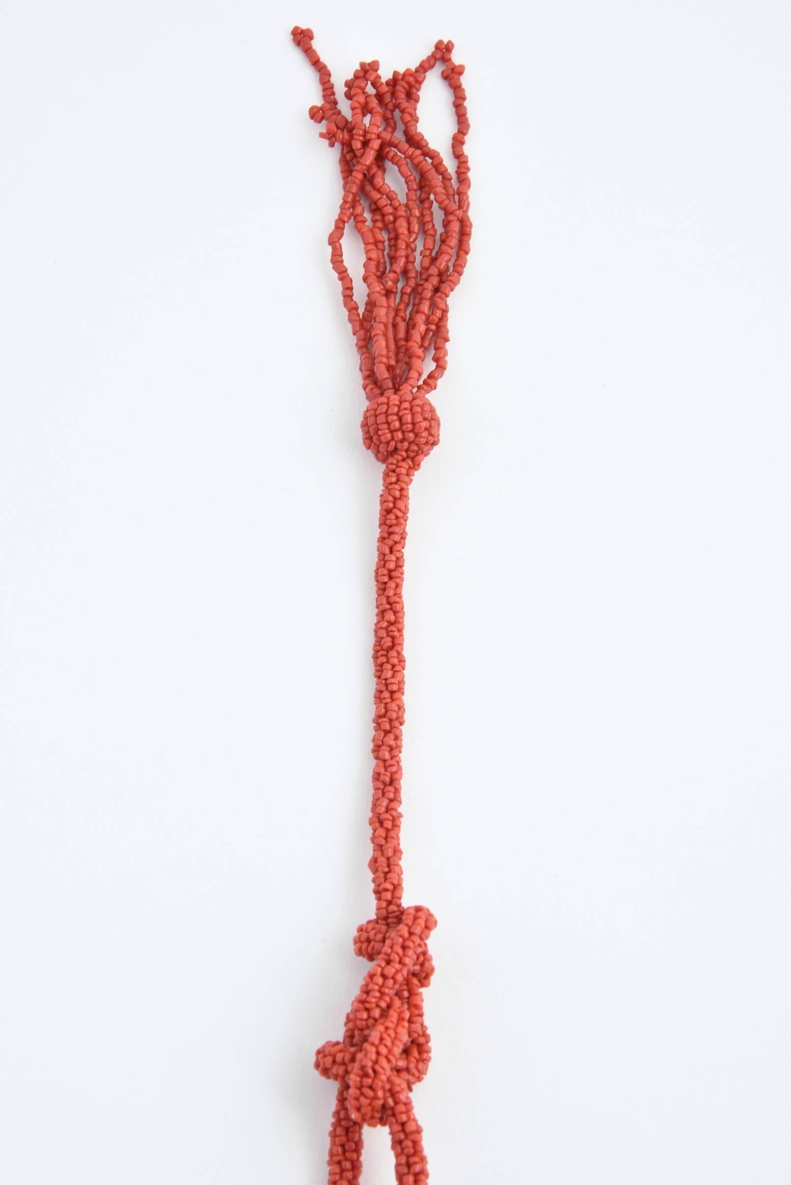 Long handwoven red coral tassel lariat necklace. No maker's mark.