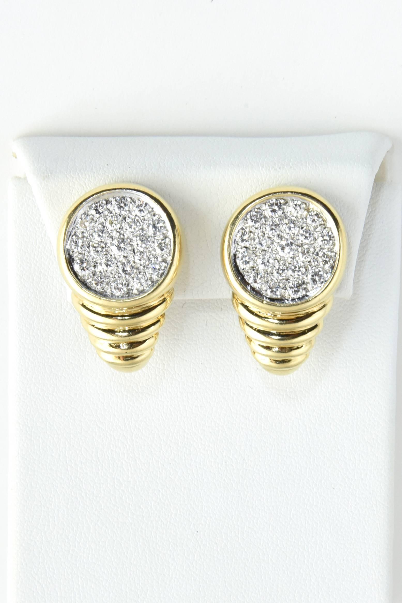 Beautifully made 1970's earrings featuring a 14k white gold circle set with approximately 2 carats of pave diamonds.  The circle is mounted in a 14k yellow gold bezel which sits on a ribbed gold design that gets smaller as it goes down the ear.  