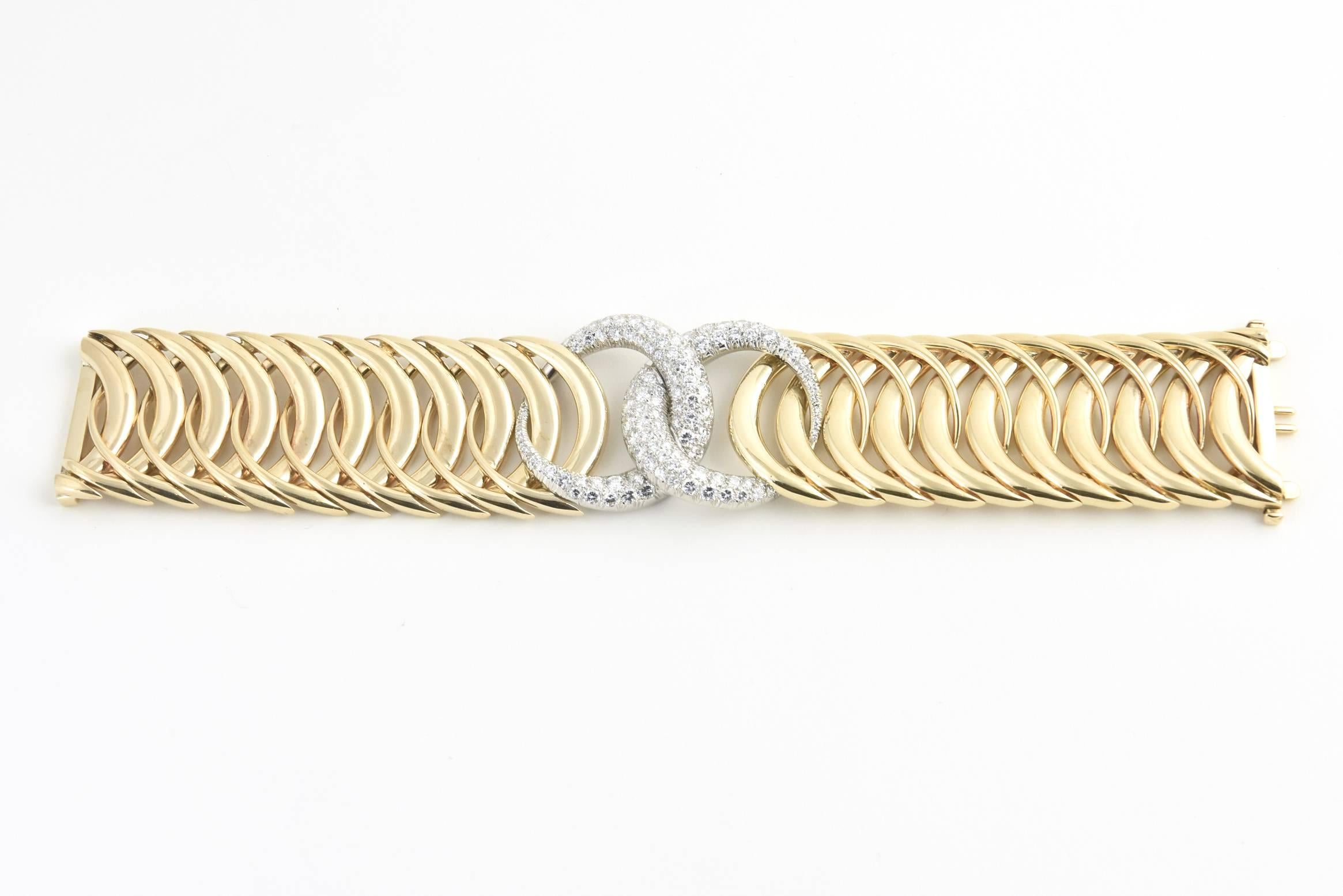 Impressive bracelet featuring two interlocked pave diamond sections with approximately 6 carats of fine quality diamonds mounted in three dimensional 14k white gold circles that are then interlocked with complementary shiny finish 14k yellow gold