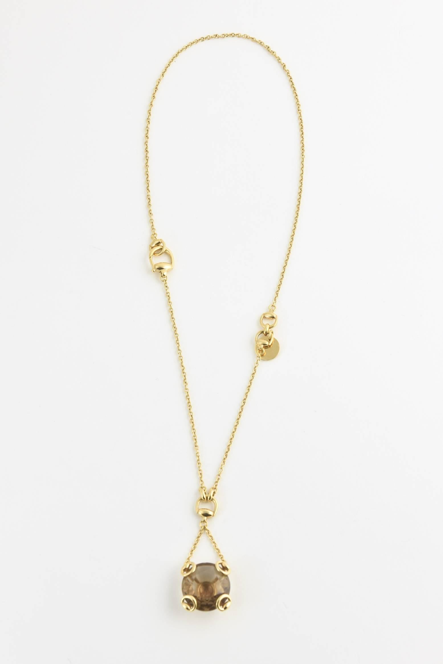 This stunning Gucci necklace features a large faceted smoky quartz engulfed in a timeless 18-karat yellow gold Horsebit Motif  

Length: 18″ followed by a drop of 1.75″ 