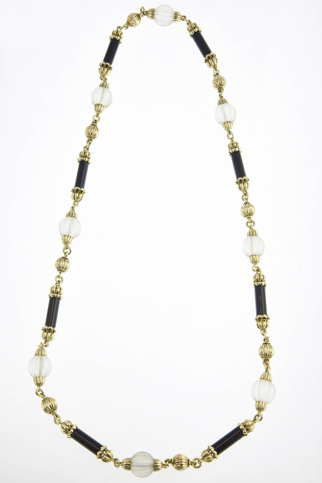 A beautifully made 18K yellow necklace with ribbed gold and crystal beads intermixed with gold capped onyx tubes.