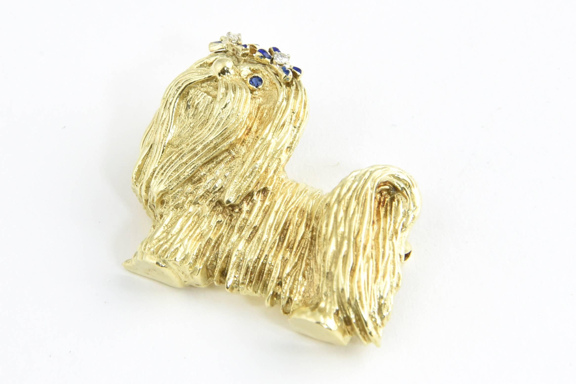 This playful figural puppy dog pin was produced in the 1970s. It could be a Yorkie, Maltese, Shih Tzu or just a cute puppy, your choice.  A pair of blue enamel bows set with diamonds hold the hair back so you can see the faceted sapphire eyes. This
