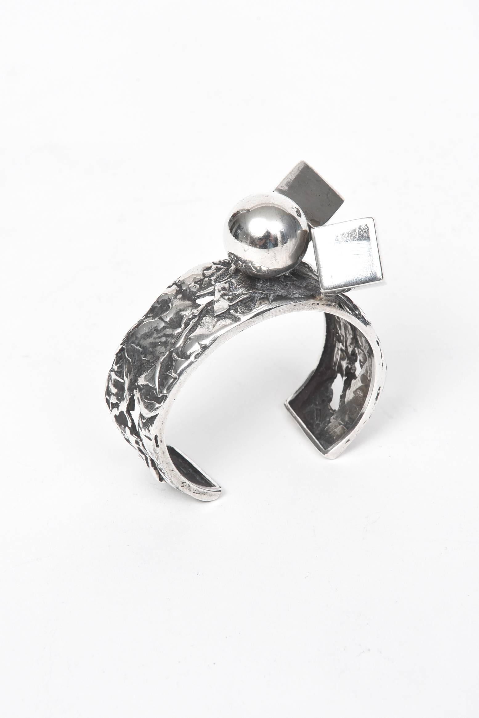 A wide, handmade sterling cuff with ball & cube accents by Israeli designer, Rachel Gera.  Rachel Gera's silver jewelry has adorned leading celebrities. She creates three-dimensional silver work, which has won international acclaim.

Her