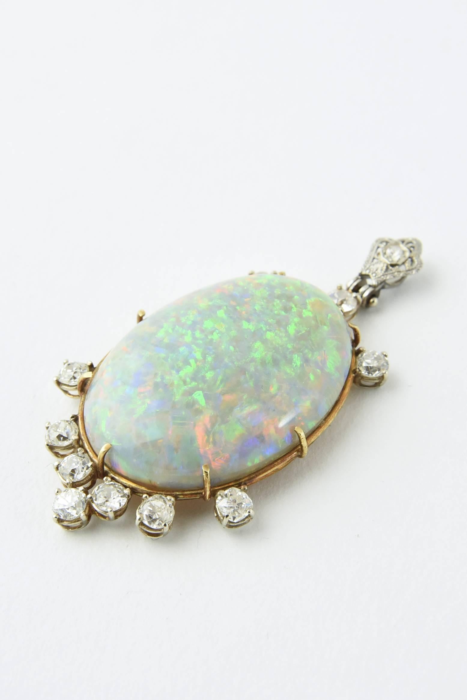 The intense color play shown by this Australian Gray Opal is incredible.  The large oval opal is approximately 18 carats with 2.25 carats approximate total weight in old mine cut diamond accents.  

Mounted in a 14k gold bezel.
The opal is