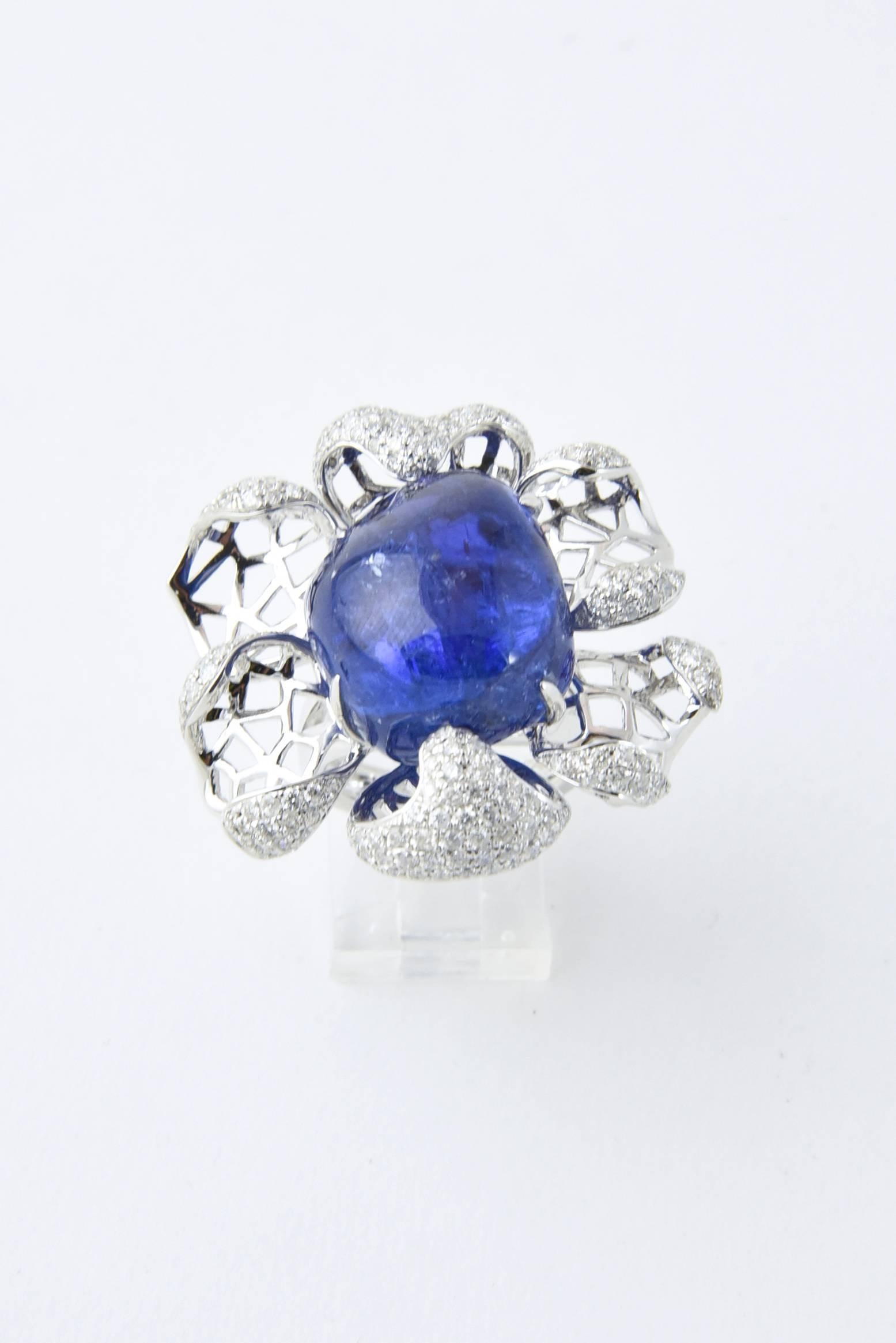 Impressive three dimensional flower cocktail ring featuring open gold work and pave diamond petals with a centralized 54 carat cabochon tanzanite.