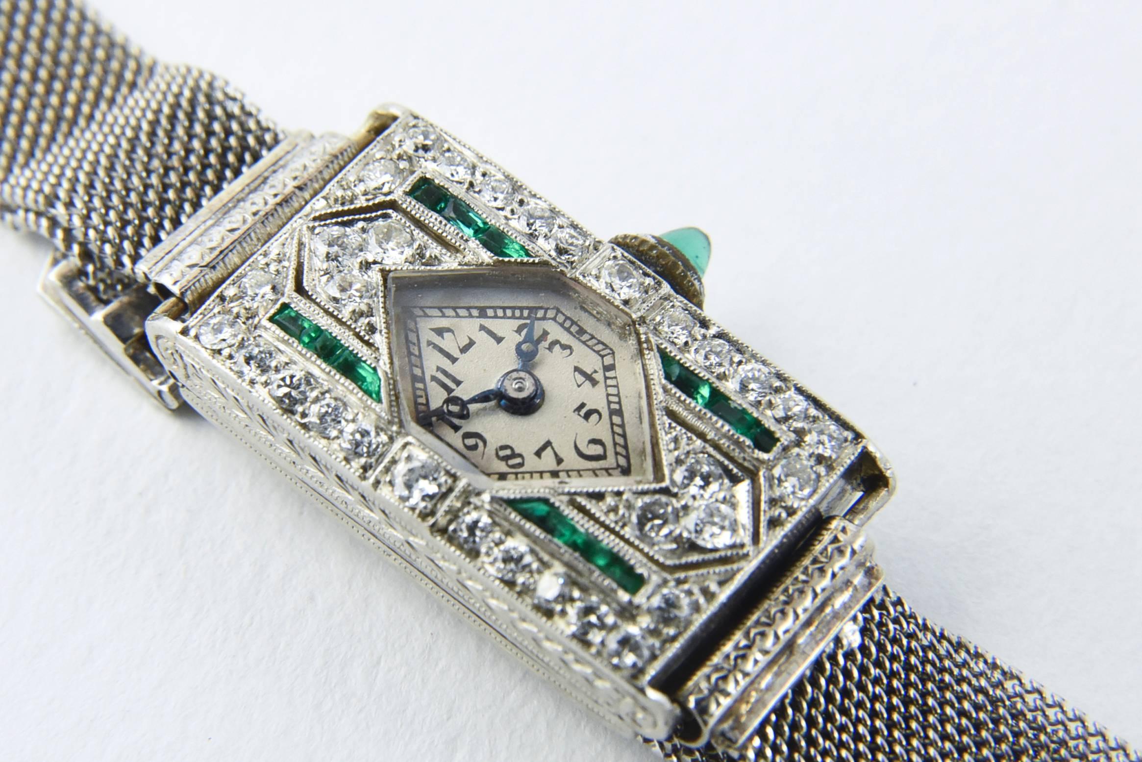 Antique Art Deco Glycine Watch featuring a platinum case with a diamond shaped face and channel set emeralds and prong set diamonds on a platinum mesh band.  Glycine Swiss movement.

Measurement below is the case with out stem.