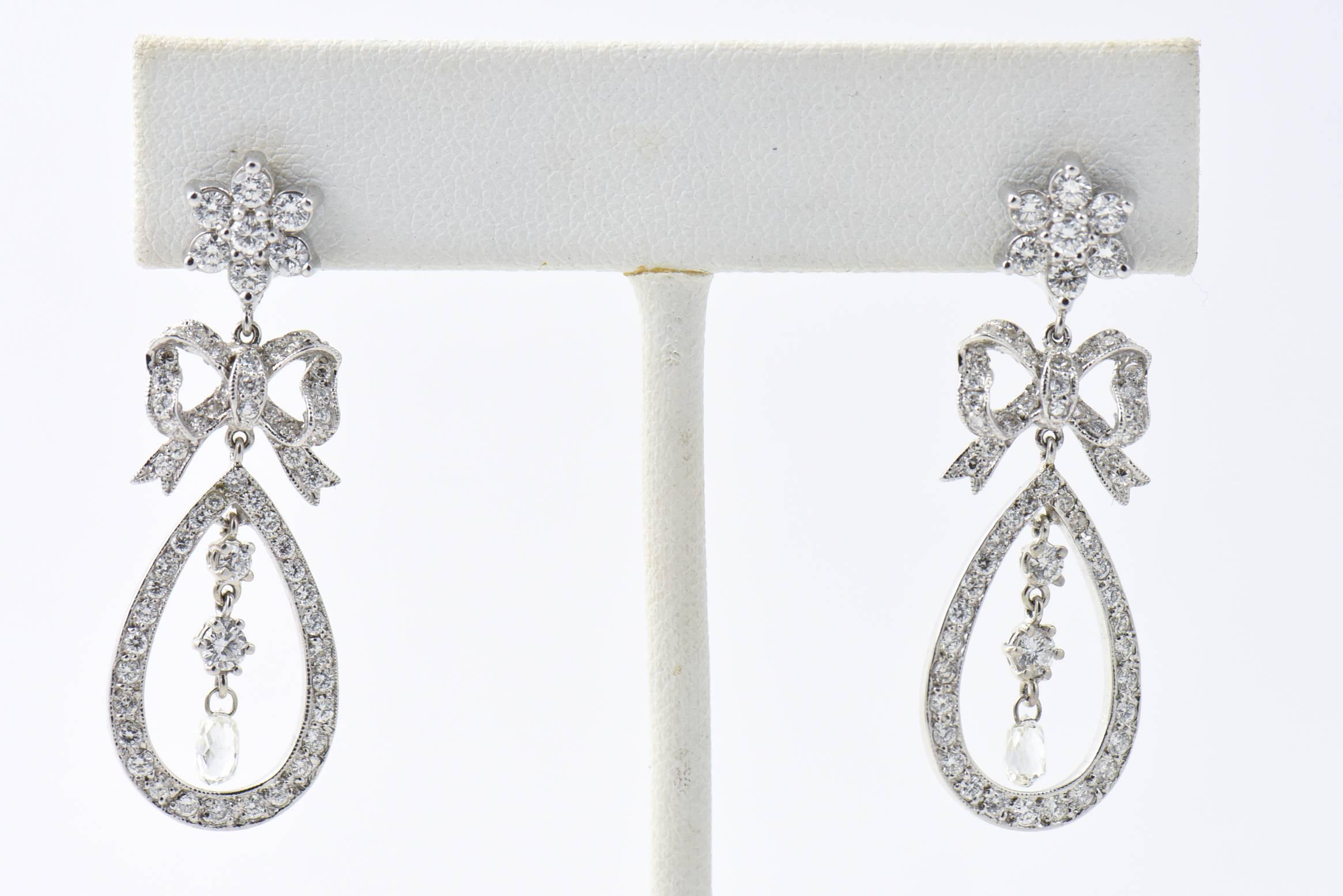 Belle Époque Style Delicate Diamond Bow and Flower Drop Ohrringe aus 18 Karat Weißgold mit 1,92 Karat an runden Diamanten und 0,61 Karat an  roh geschliffene Briollets mit einem ungefähren Gesamtgewicht von 2,53.  

Diese Ohrringe sind perfekt für