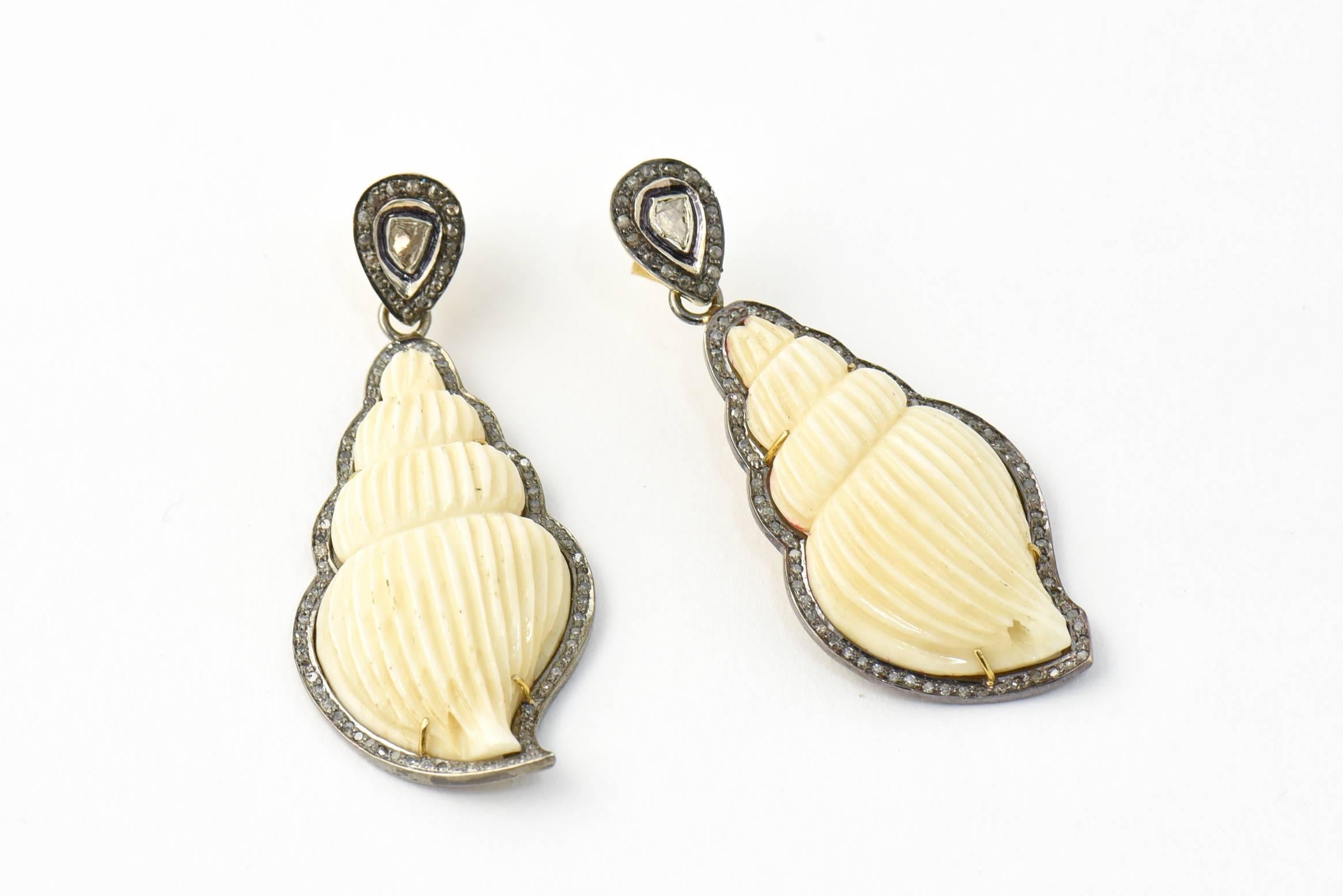 Wonderfully carved bone in the shape of shells mounted in a custom made diamond and sterling frame that imitates the shell edges.  The shells dangle off a rose diamond and Sterling teardrop with a 14k gold back.