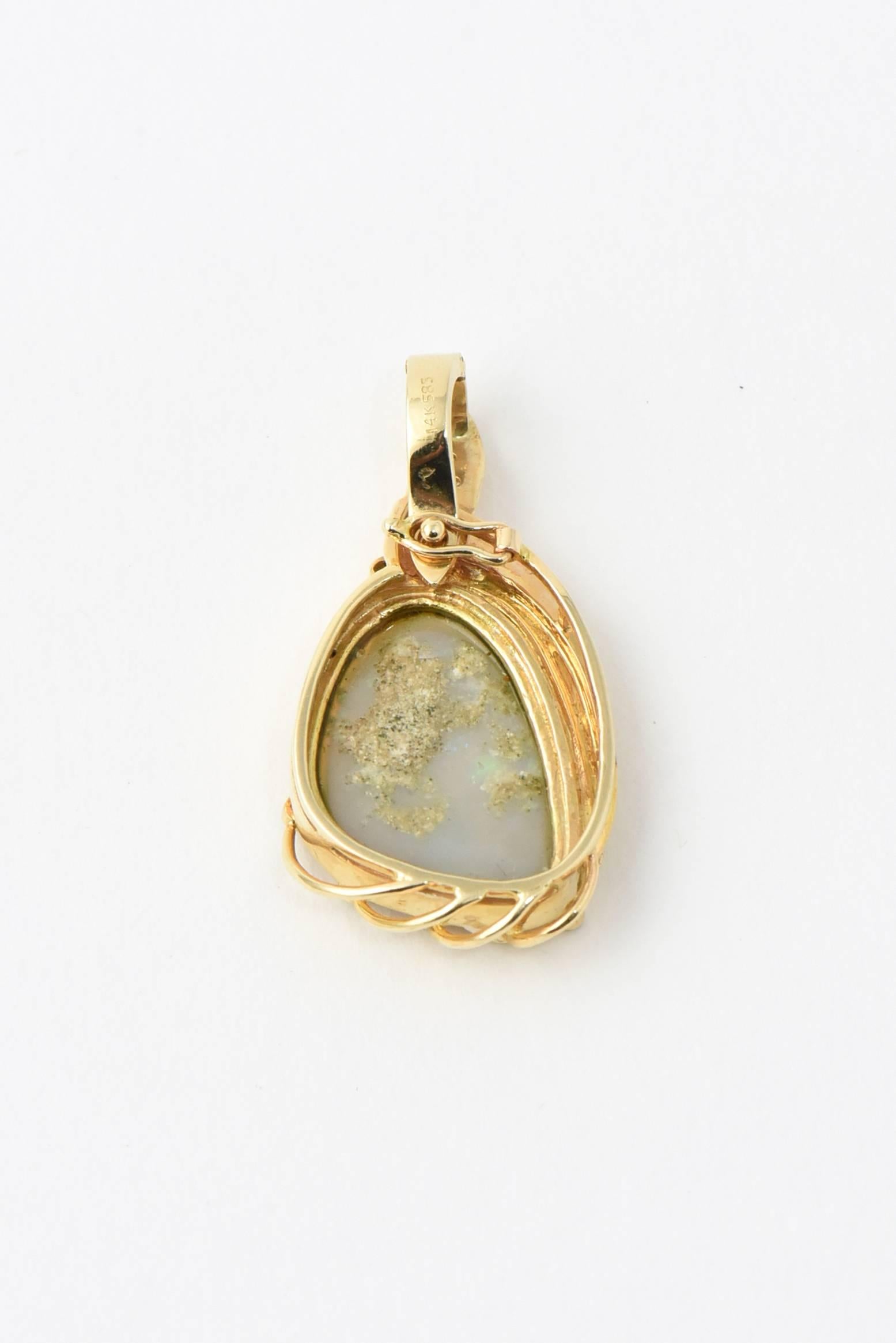 Beautiful Australian free form  opal approximately 6-7 carats mounted in a handmade custom gold and diamond fame with a hinged loop.

This fine specimen of somewhat transparent opal (crystal) has Semi Black Or grey body tone with multicolor flash