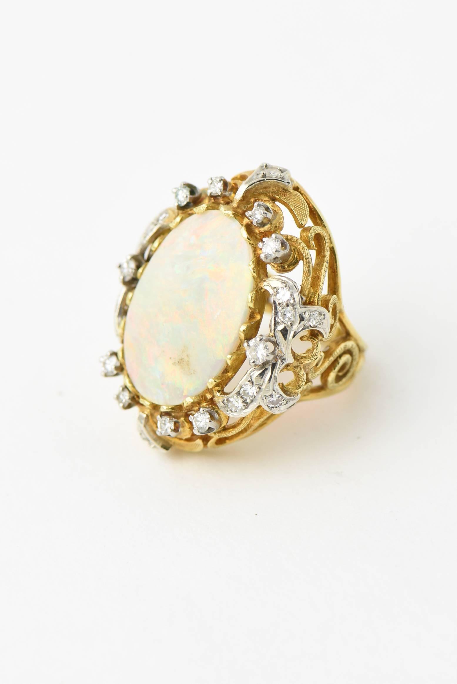 Brillant Australian 12 carat plus gray opal with beautiful flashes of colors in shades of reds, greens, blues and yellows.  The opal is accented by approximately 1 carat of diamonds mounted in a handmade openwork scroll ring.

US size 4.75.