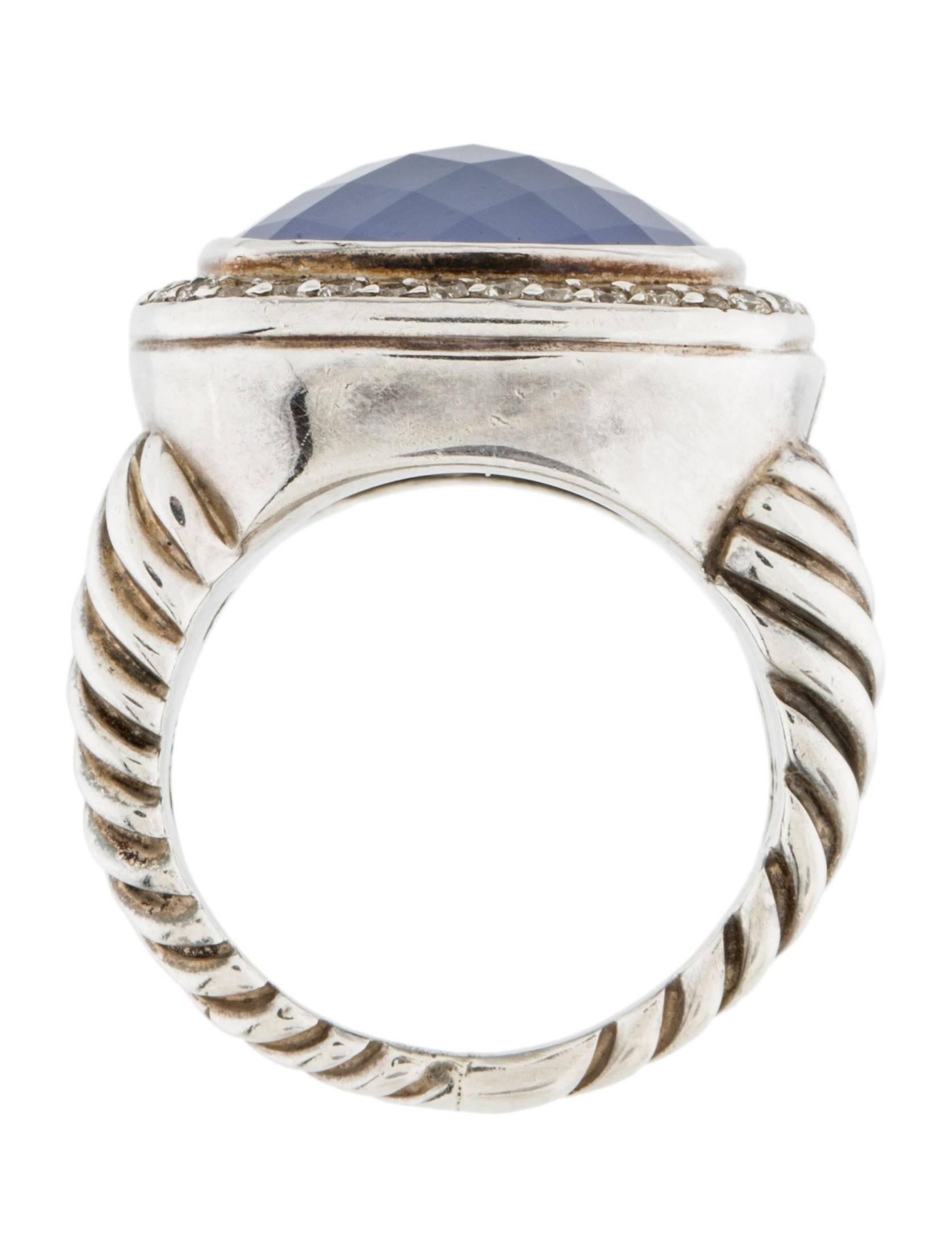 Sterling silver David Yurman Albion ring featuring blue faceted chalcedony surrounded by a halo of round pave diamonds approximately  0.34 carats in diamonds.
Band Width 13mm
Ring Size: 5.75
Marked 925 Yurman Hallmark