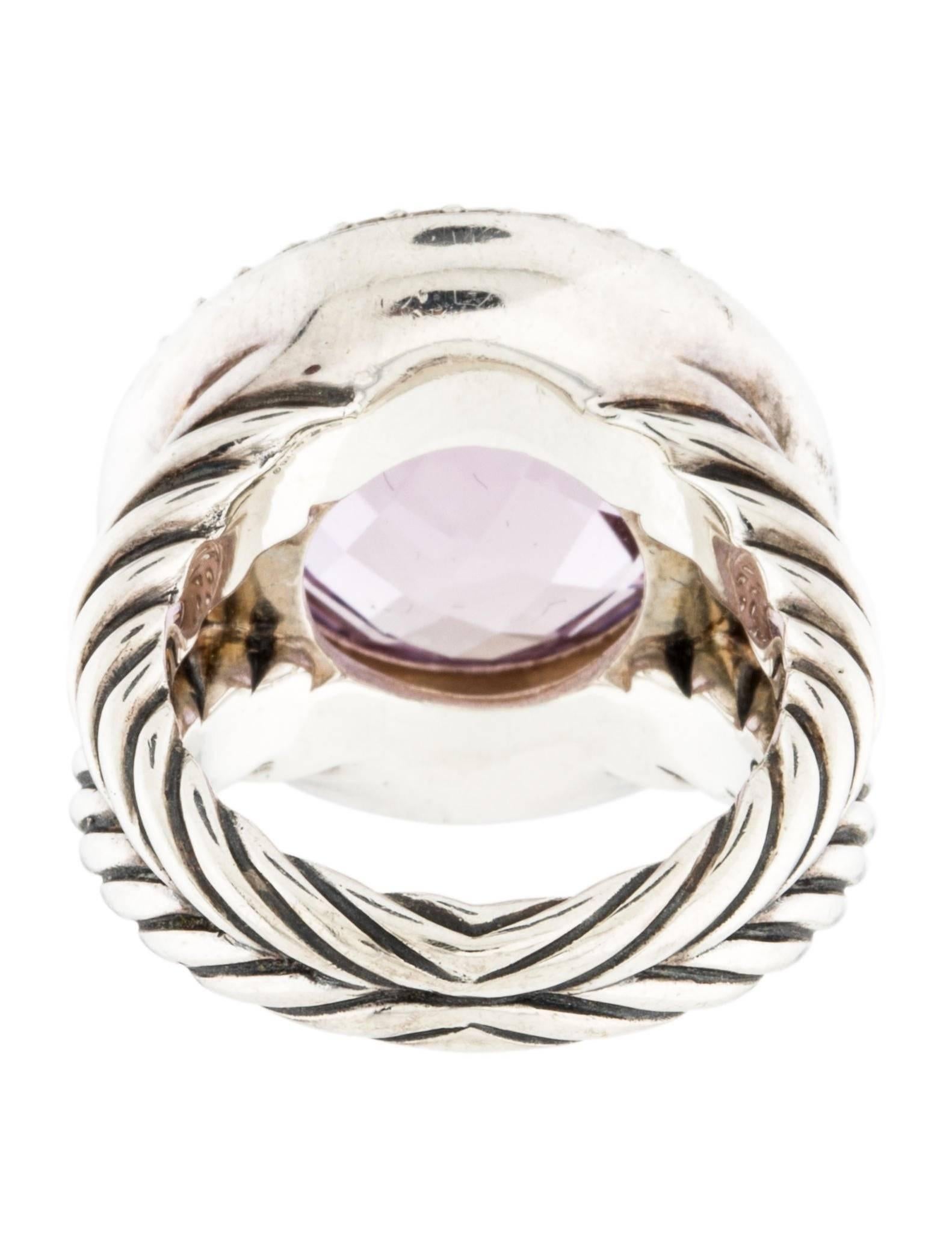 Sterling silver David Yurman Cerise ring featuring purple amethyst at center and 0.54 carats of pavé round brillaint diamonds at halo. Band width 10mm
Ring Size: 6
Marked 925 with Yurman Hallmark
