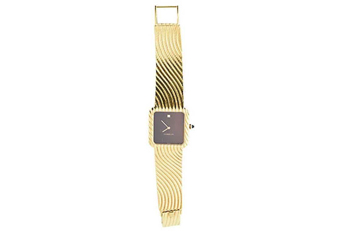 Gubelin 18K yellow gold manual wind wristwatch, circa 1960, Black dial with diamond at the 12 o'clock and a gold wave design on the case and band. Sapphire crown. The watch band is short (the size ranges from 5.75