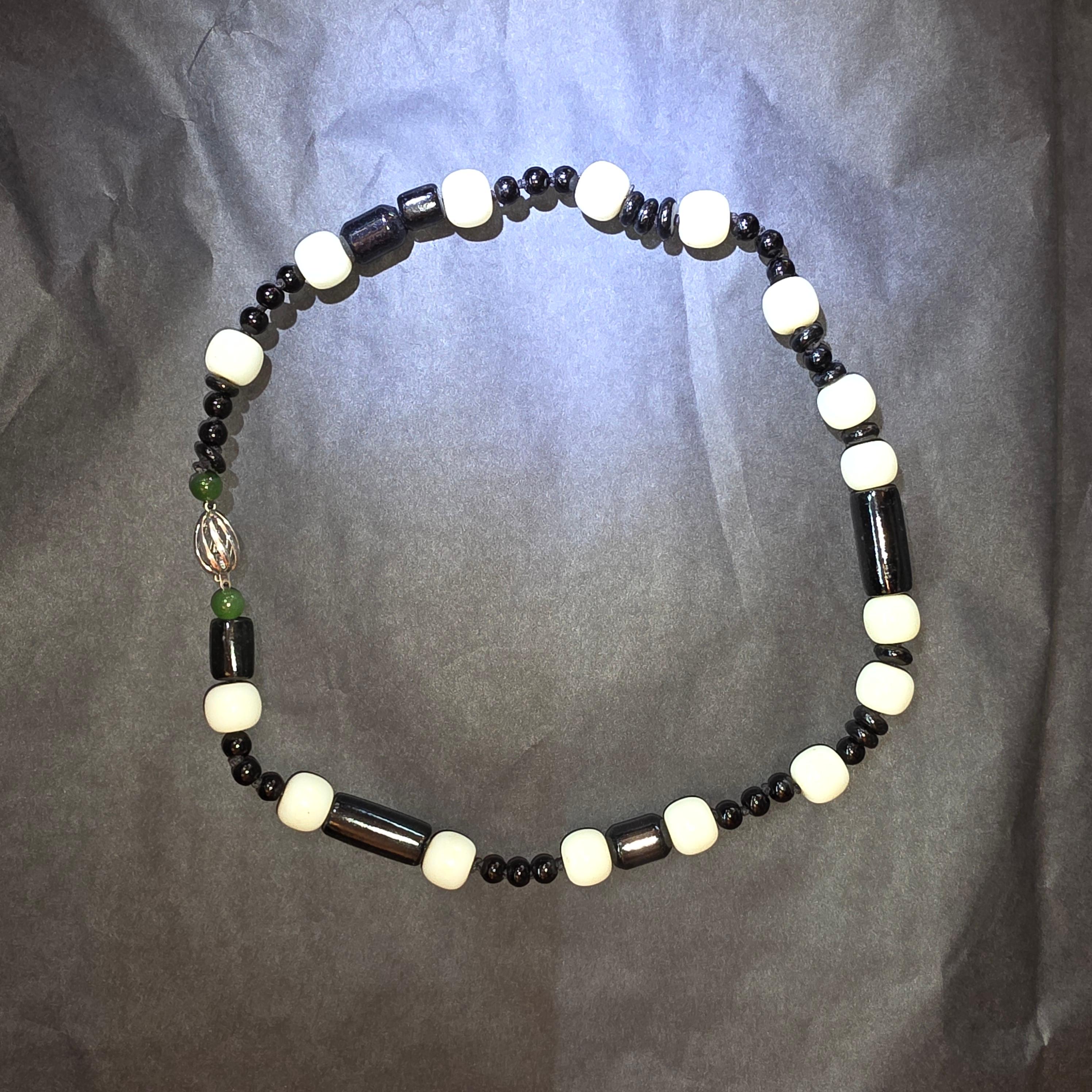 Trente-sept perles de jade noir du Guatemala, rondes, en forme de disque et cylindriques, naturelles et non traitées, ainsi que seize perles de jade néphrite blanc non traité de 12 mm, créent ce collier de 20 pouces d'une qualité et d'un style