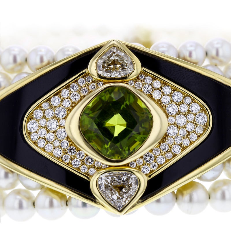 Composed of six rows of cultured pearls, decorated with a navette-shaped motif set with black onyx and accented by pave diamonds. Centered by a sumptuous cushion-cut peridot, flanked by two white pear-shaped diamonds 2 carats. Circa 1980s.