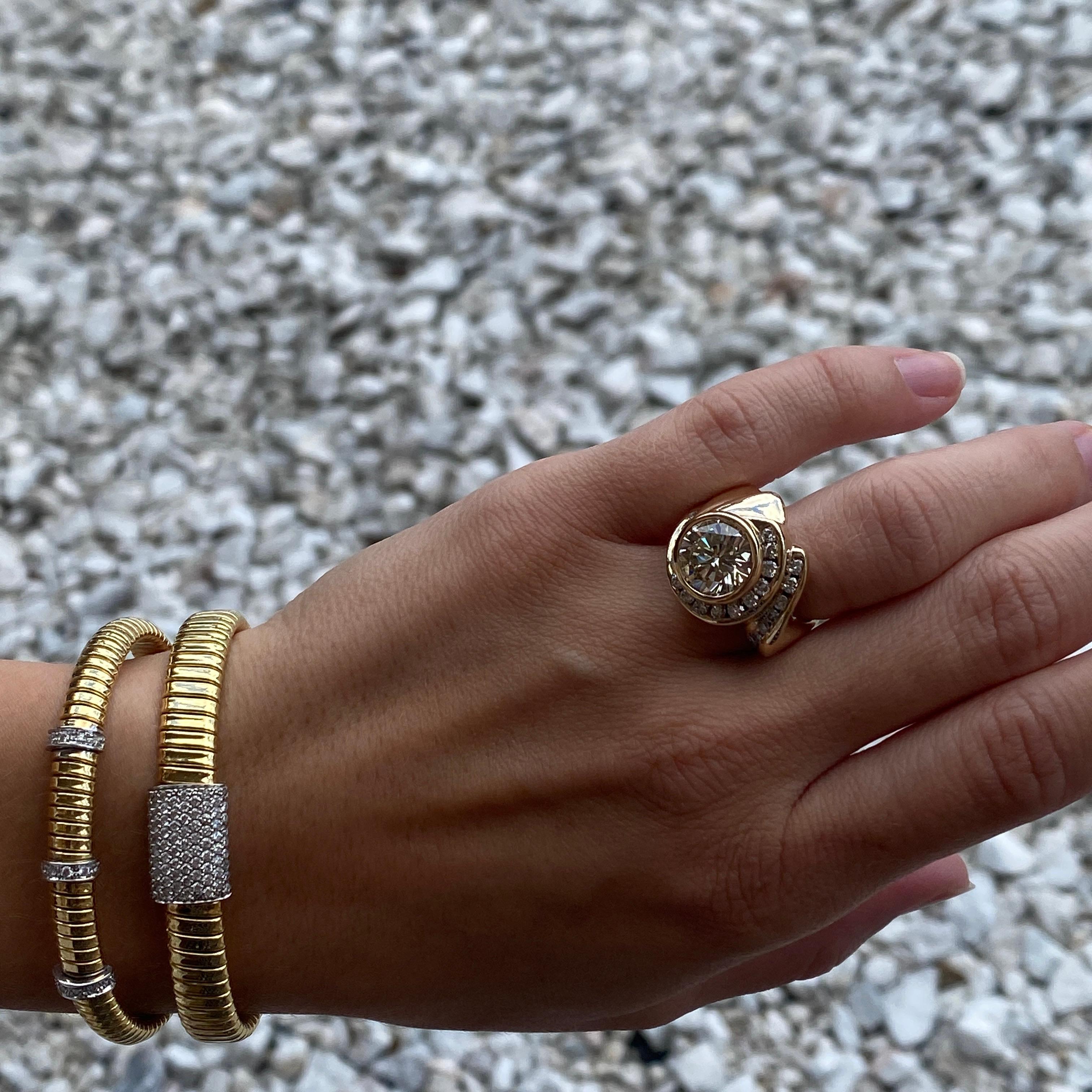 Il s'agit d'une création audacieuse, tourbillonnante et asymétrique, réalisée sur mesure avec un gros diamant rond pesant 3,99 carats. Le diamant central a fait l'objet d'un rapport d'évaluation GIA et est en outre signé et estampillé par le