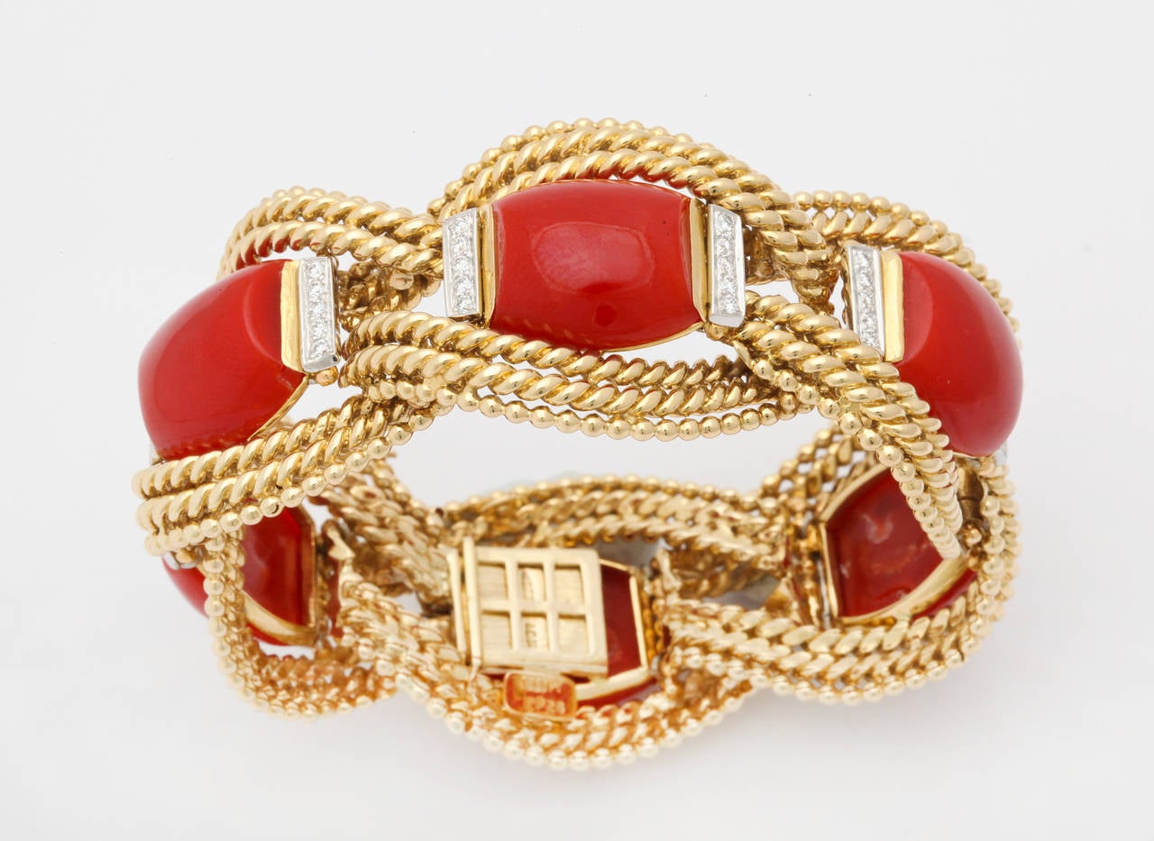David Webb was the true master of color and bold design, and this bracelet is a perfect example of his work.  Six uniquely shaped coral cabochons are framed in diamonds and set within the beautiful rope gold bracelet.  In perfect condition, this
