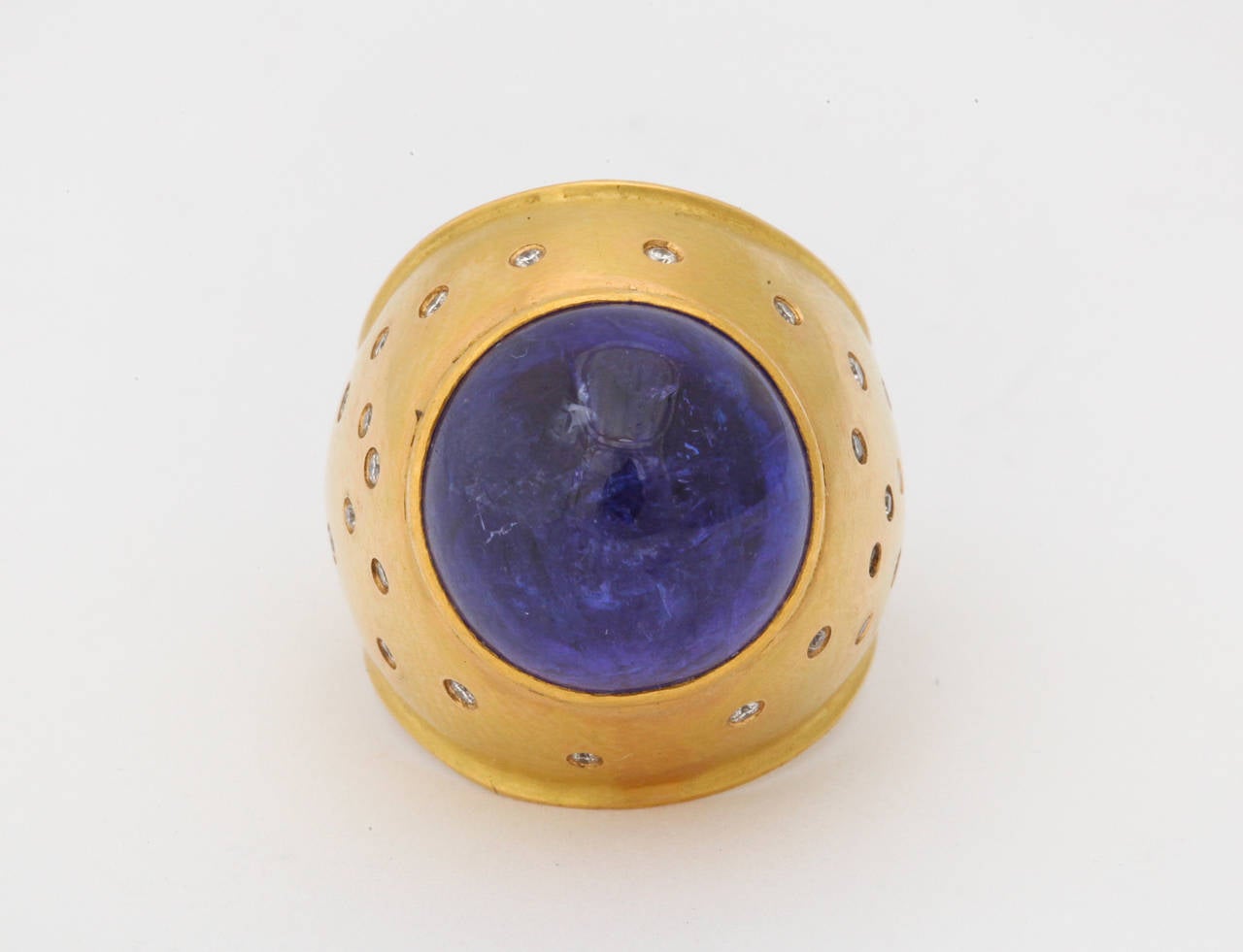 The central cabochon tanzanite is set in a bold 18kt yellow gold mounting, accented with 24 round diamonds.  Size 5 1/2.
