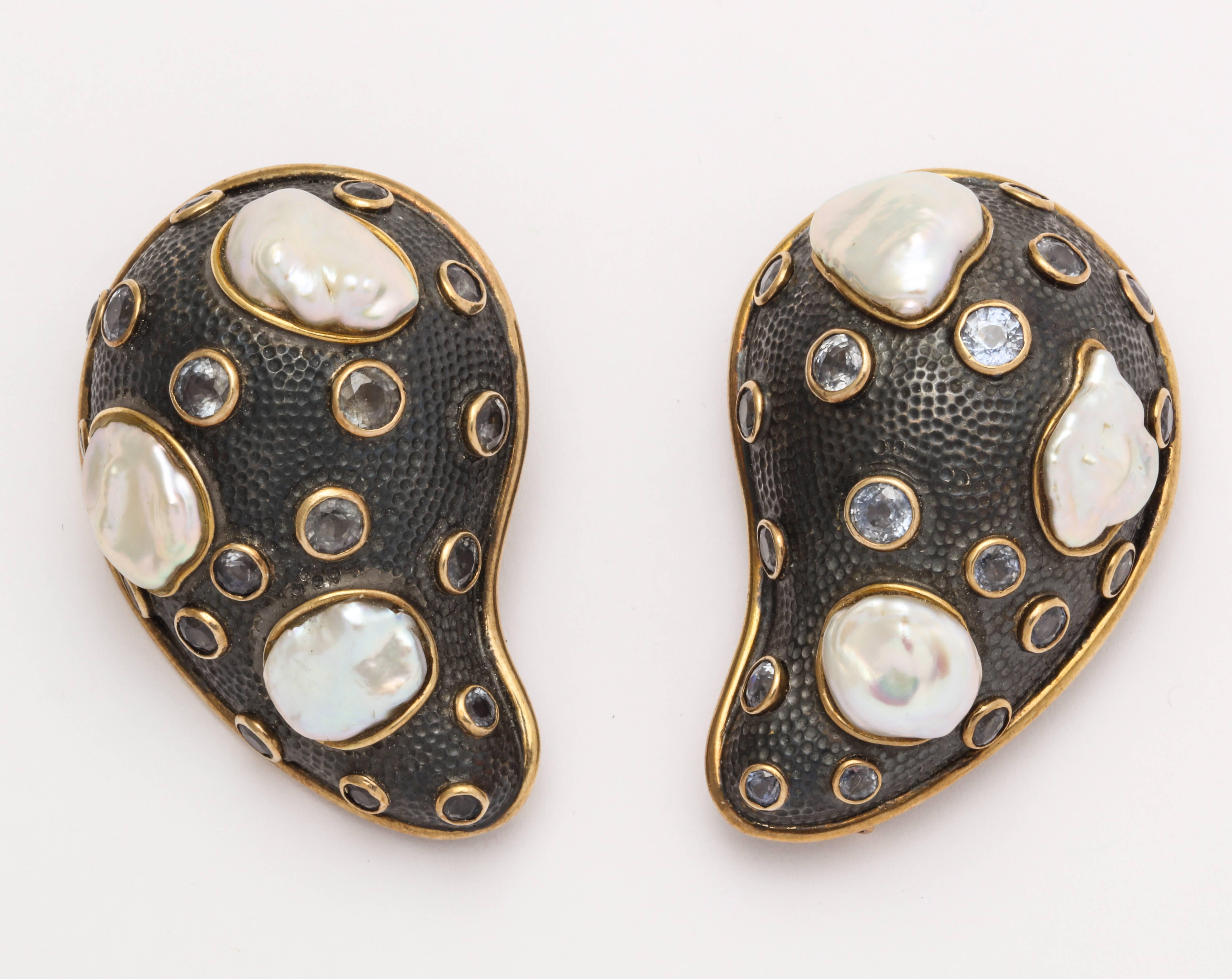 One of a kind and always exceptionally creative, Marilyn Cooperman's designs never fail to impress.  This wonderful pair of pins is very carefully designed on numerous levels.  The combination of the dark patinated silver, with a hand hammered