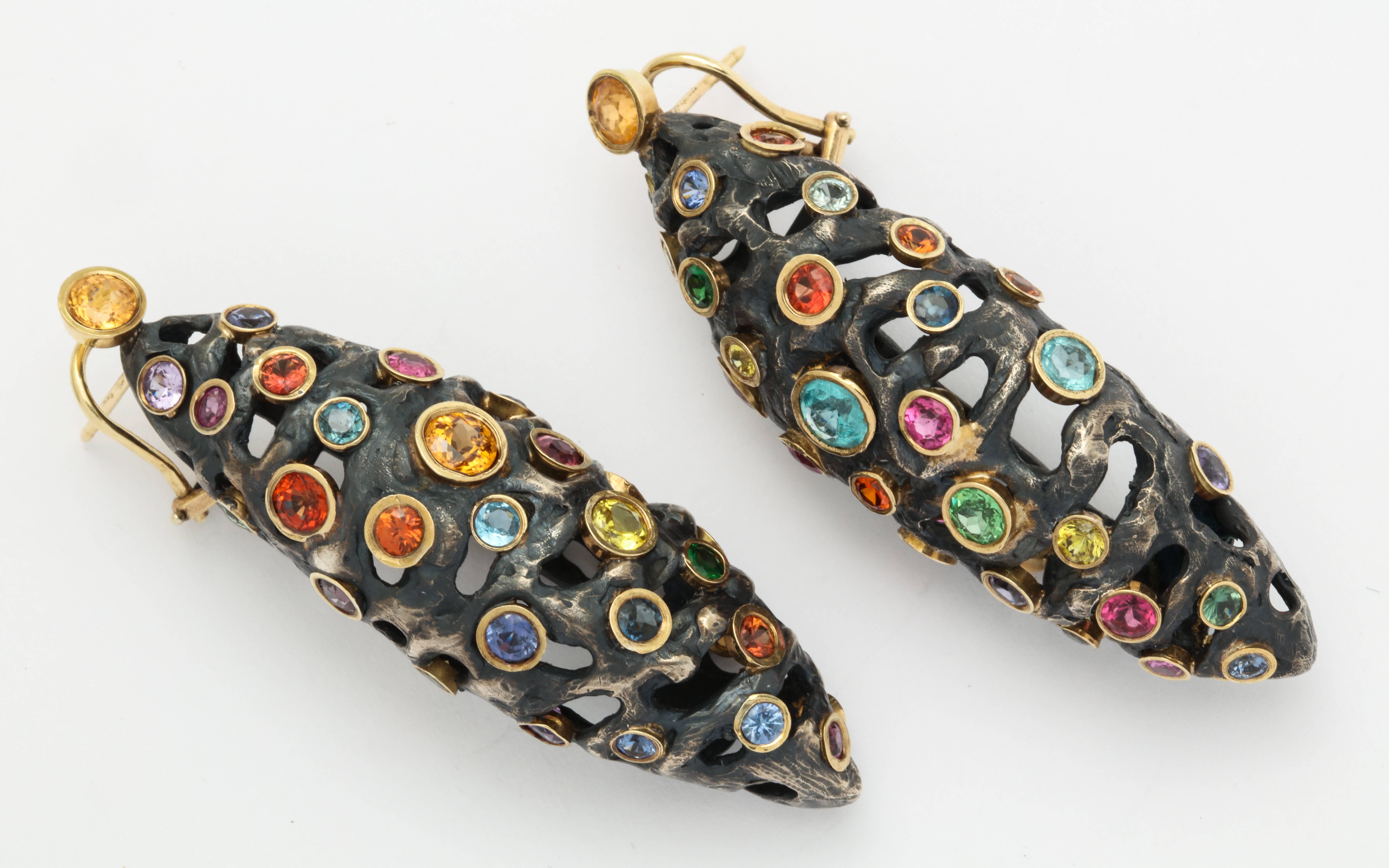 Set with a variety of brightly colored gemstones including sapphire, citrine, amethyst, topaz and tsavorite, these fantastic earrings are truly one of a kind.  The mounting utilizes Cooperman's signature patinated silver, which lends a dramatic