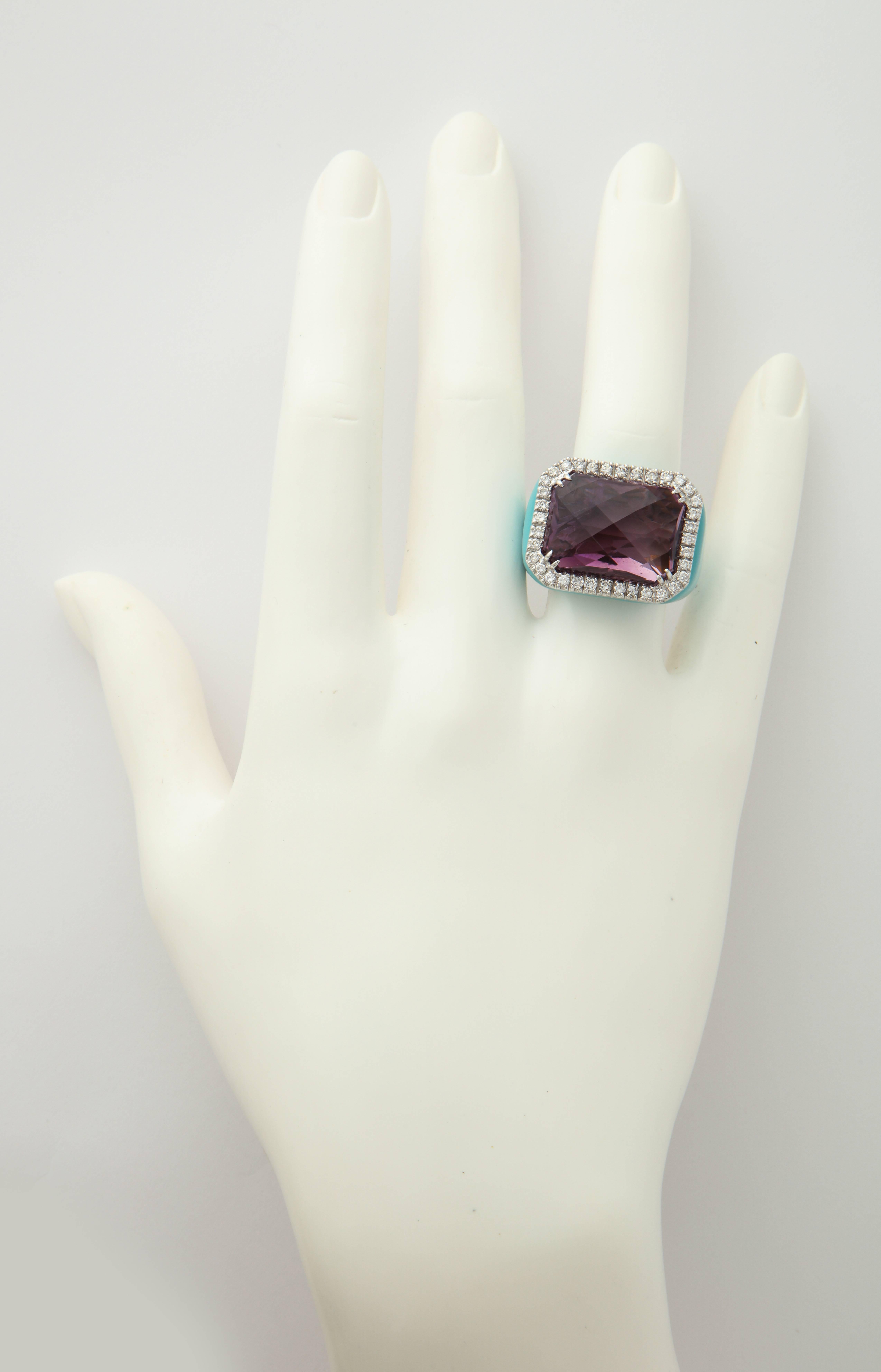 A beautifully faceted emerald cut amethyst (17.80cts), surrounded by diamonds (0.84cts) in a turquoise enamel mounting.
Size 6 with an internal spring guard for comfort and stability.
Made in Italy.