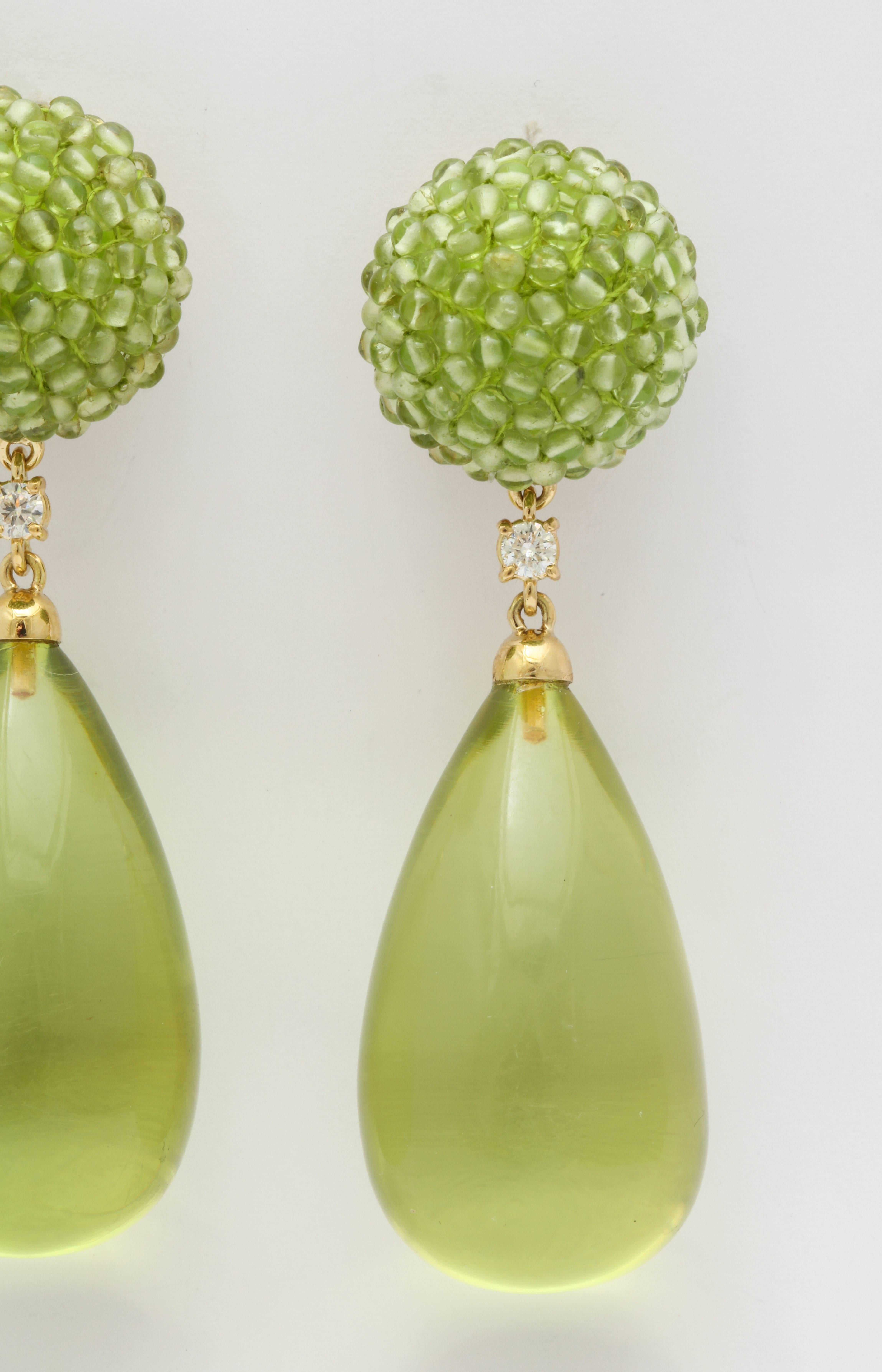 Bright, bold and fun, these great earrings are guaranteed to light up your day.  The button shaped tops are made of carefully strung peridot beads and the drops are made of amber.  Connecting the two are round diamonds and the mounting is 18kt gold.