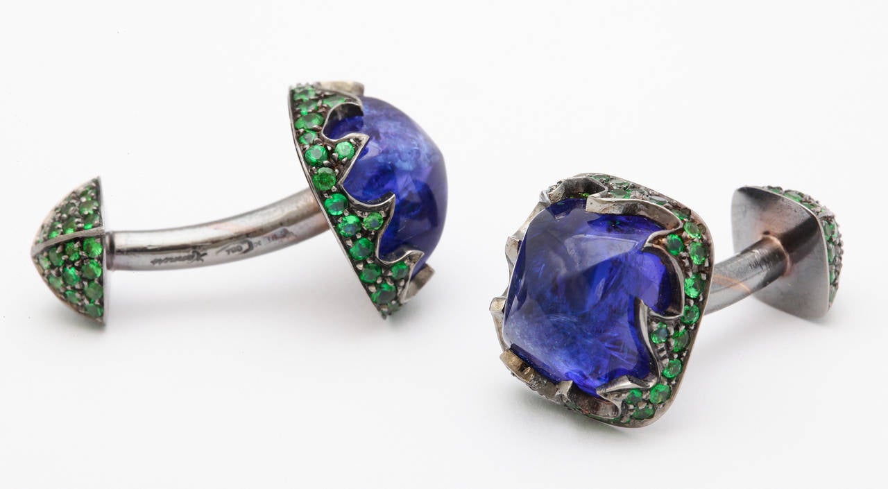 Featuring a pair of sugarloaf cut tanzanites weighing 10cts each, these cufflinks were a menswear design winner in the American Gem Trade Association's Spectrum Awards competition.  The unique blackened 18t gold mounting is completely set with over