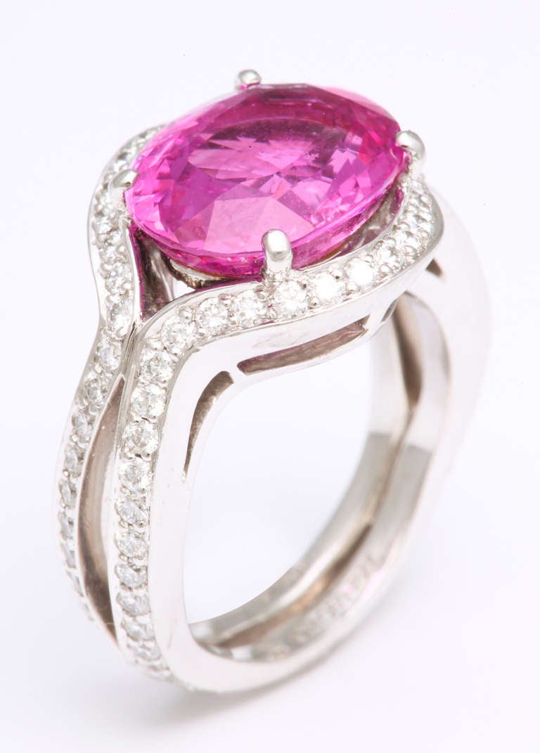 A sparkling, bright pink oval sapphire weighing 6.19cts is delicately framed in platinum and diamonds, by one of the finest workshops in New York.  Presently size 6, but can be sized to fit.

From a family of jewelers dating back to 1927, Michael