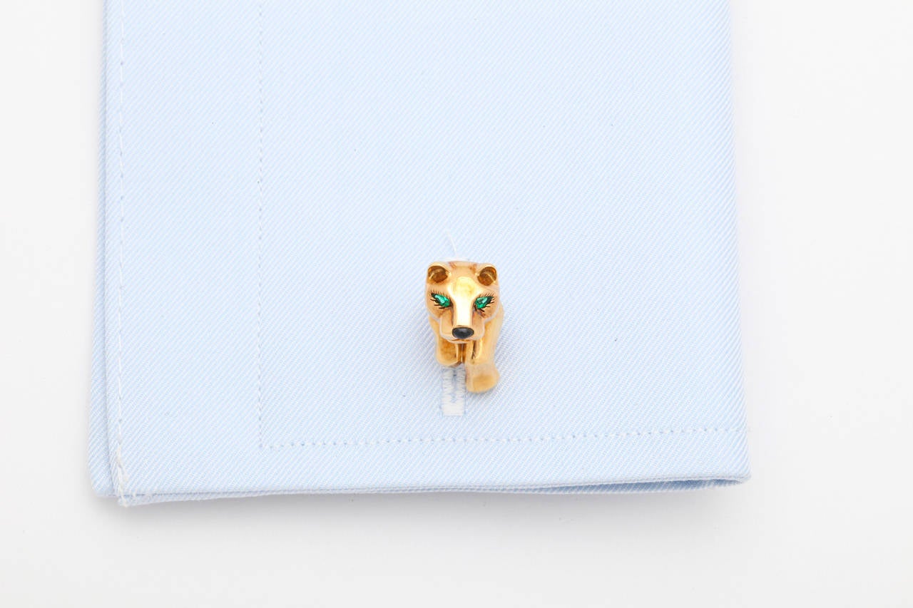 These quintessential Cartier Panthère cufflinks feature a polished panther's head with pear shaped emerald eyes and an onyx nose and are joined by a gold post to a bamboo motif spring back.  Made in France, signed, numbered and hallmarked.

For