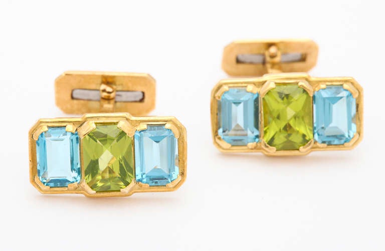 These cufflinks feature a bright combination of emerald cut peridot and sky blue topaz.  All mounted in 18kt gold with a spring back, also in the shape of an emerald cut.

Cufflinks designed by Michael Kanners are known the world over for their
