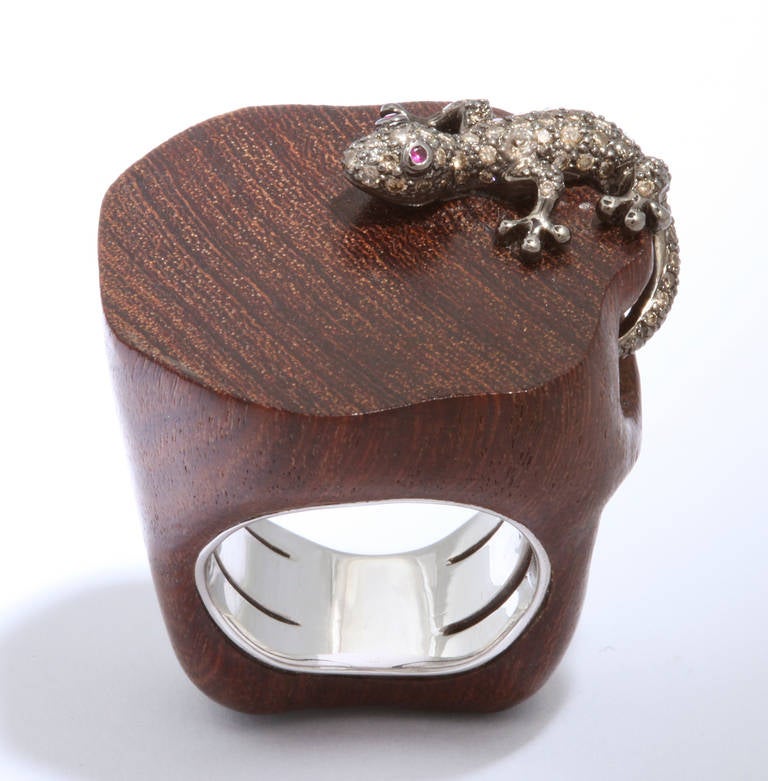 Finely handcrafted and absolutely unique, this chic ring is sure to attract attention.  The salamander is set with cognac colored diamonds and ruby eyes and the wooden ring is lined in 18kt white gold.  An interior stabilizer spring has been added