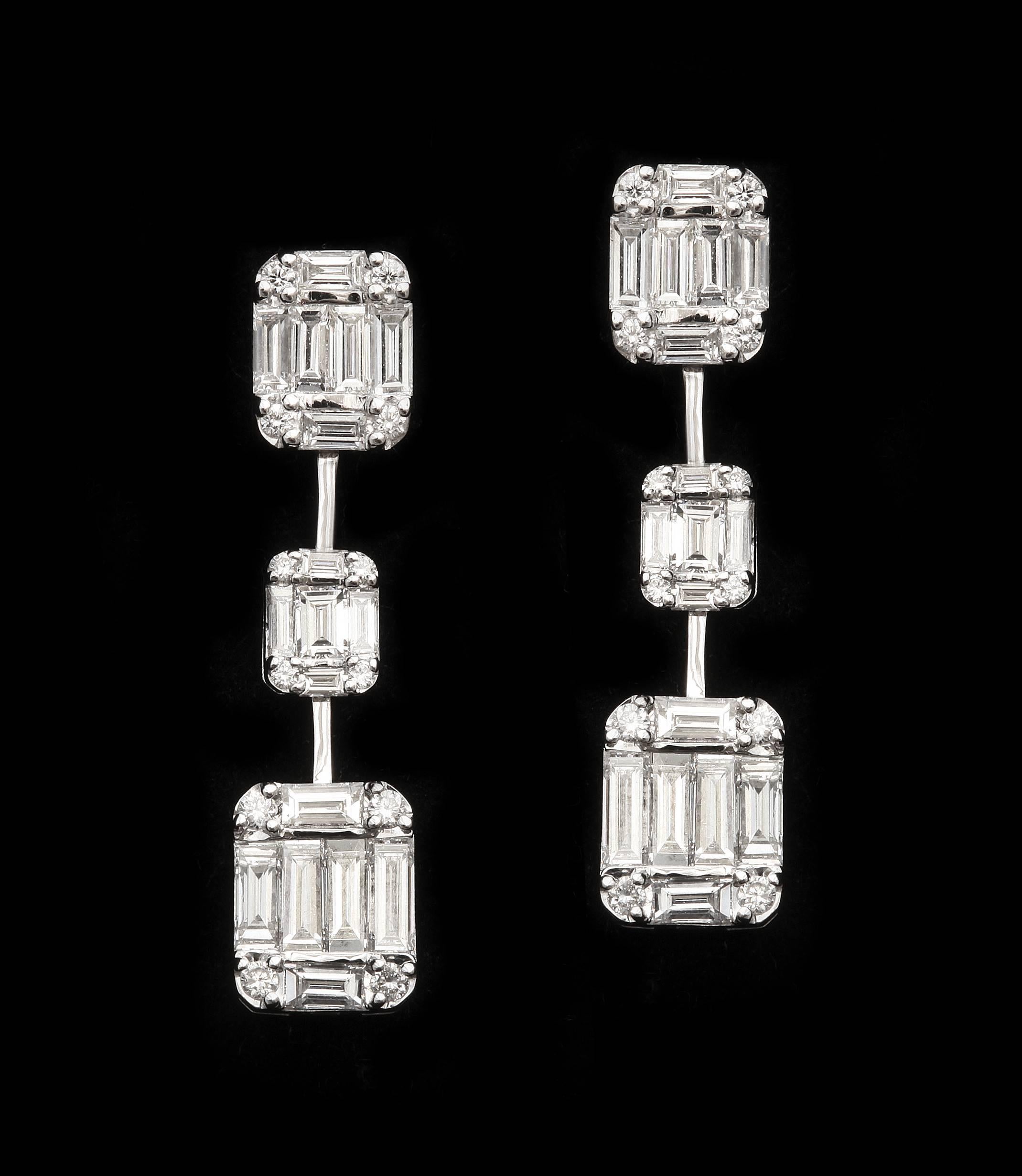 Impressive baguette diamond earrings.  The baguettes are finely matched, and expertly set in 3 emerald cut configurations per earring.  Finely made with nearly invisible connections, the stones seem to float below the ear.  Total diamond weight