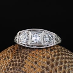 Antiker Art-Déco-Ring aus Platin mit einem Diamanten im französischen Schliff und drei Steinen im alten europäischen Stil, filigran gearbeitet